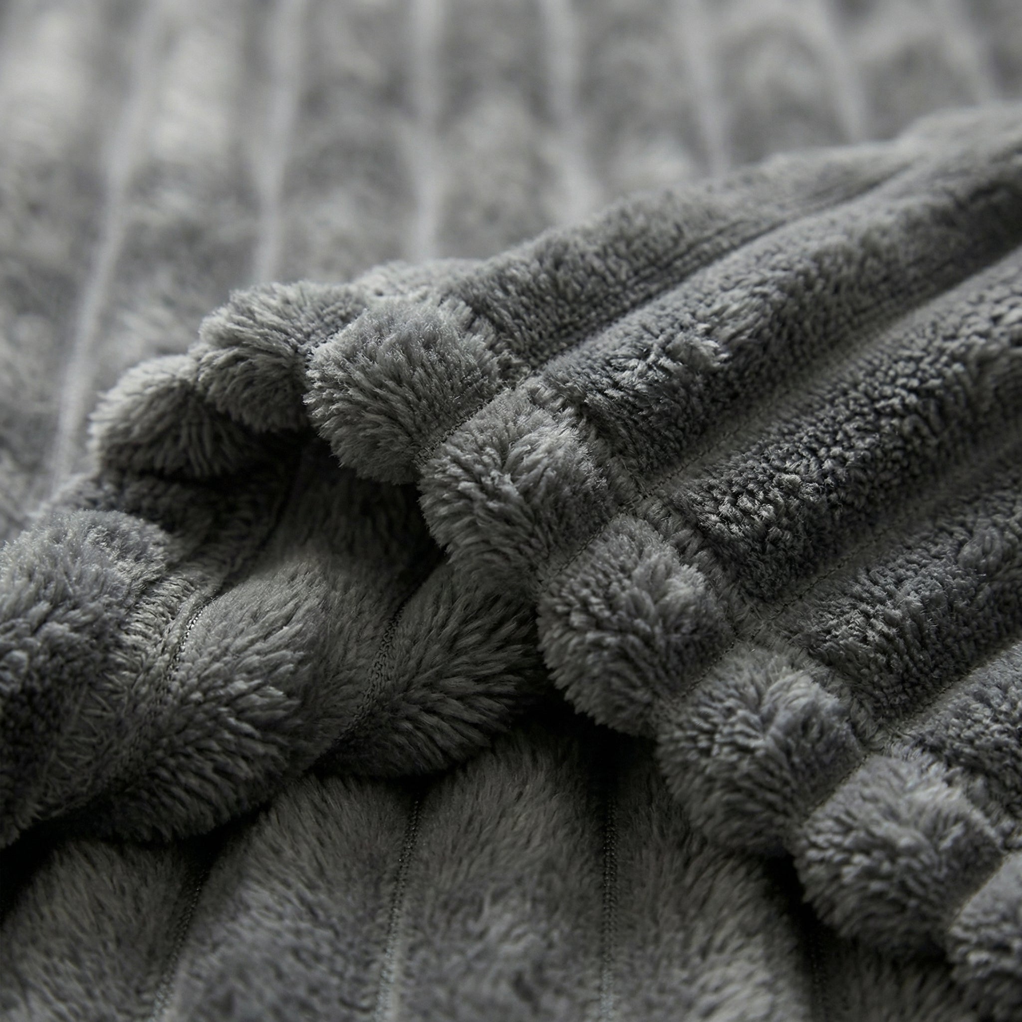 Close-up of a folded CozySoft Double-Sided Blanket in soft gray plush polyester with ribbed texture.