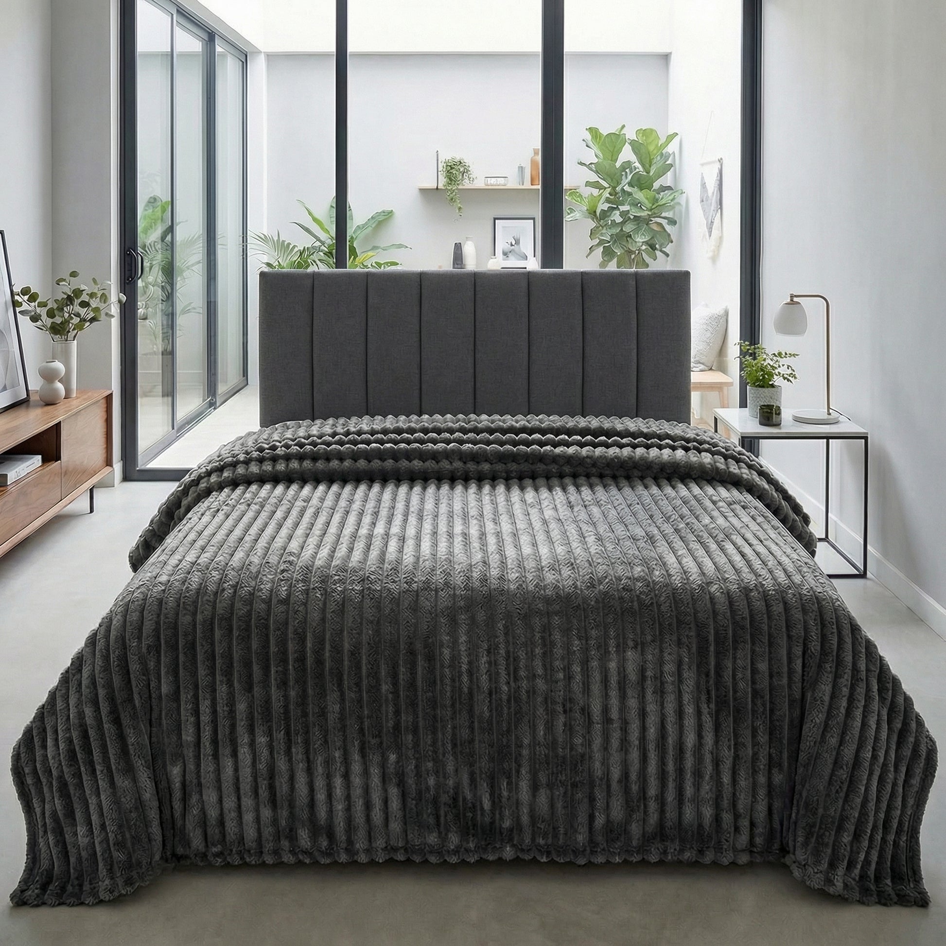 CozySoft Double-Sided Blanket in dark grey, featuring a plush, ribbed texture draped over a bed.