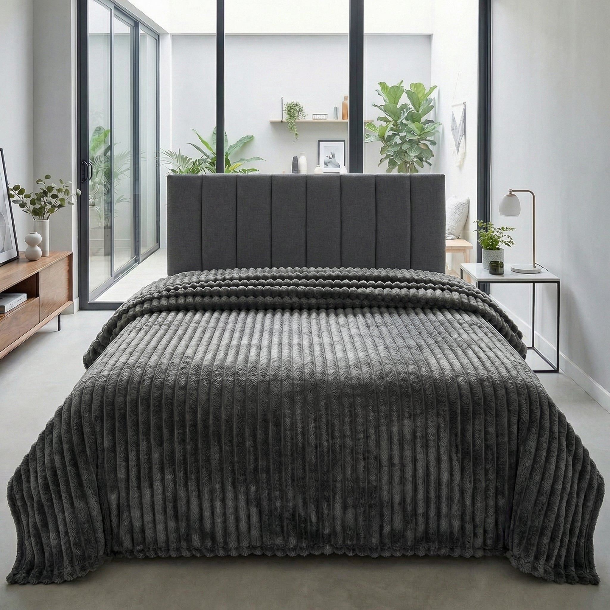 CozySoft Double-Sided Blanket in dark grey, featuring a plush, ribbed texture draped over a bed.