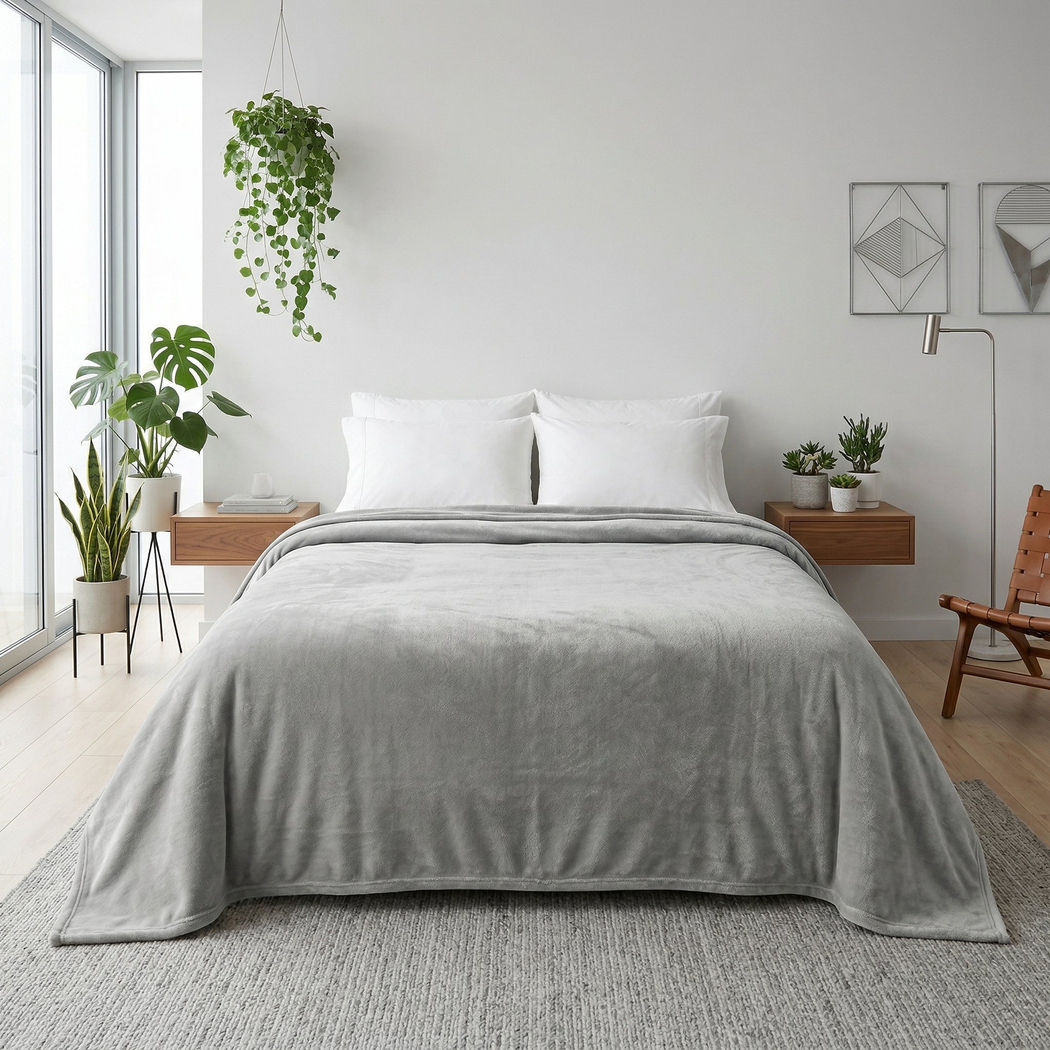 Soft gray microfiber flannel throw blanket draped over a bed with white pillows in a modern bedroom.