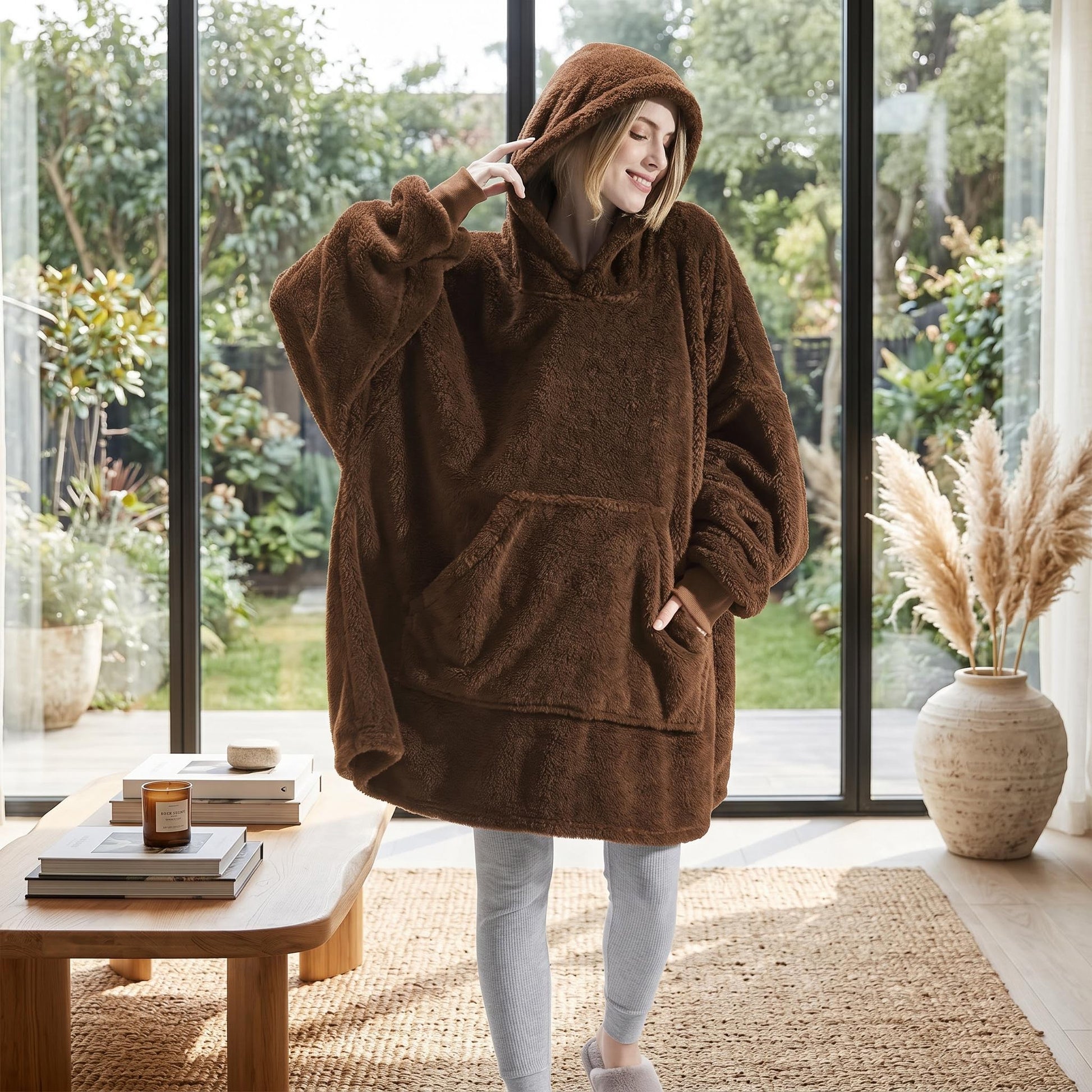 Smiling woman in an oversized brown double fleece hooded jacket with a large front pocket.