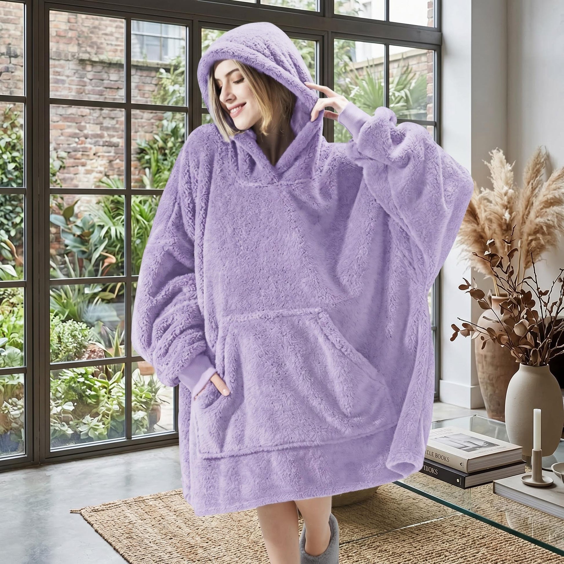 Smiling woman in a cozy, oversized lavender double fleece hooded jacket with a large front pocket.