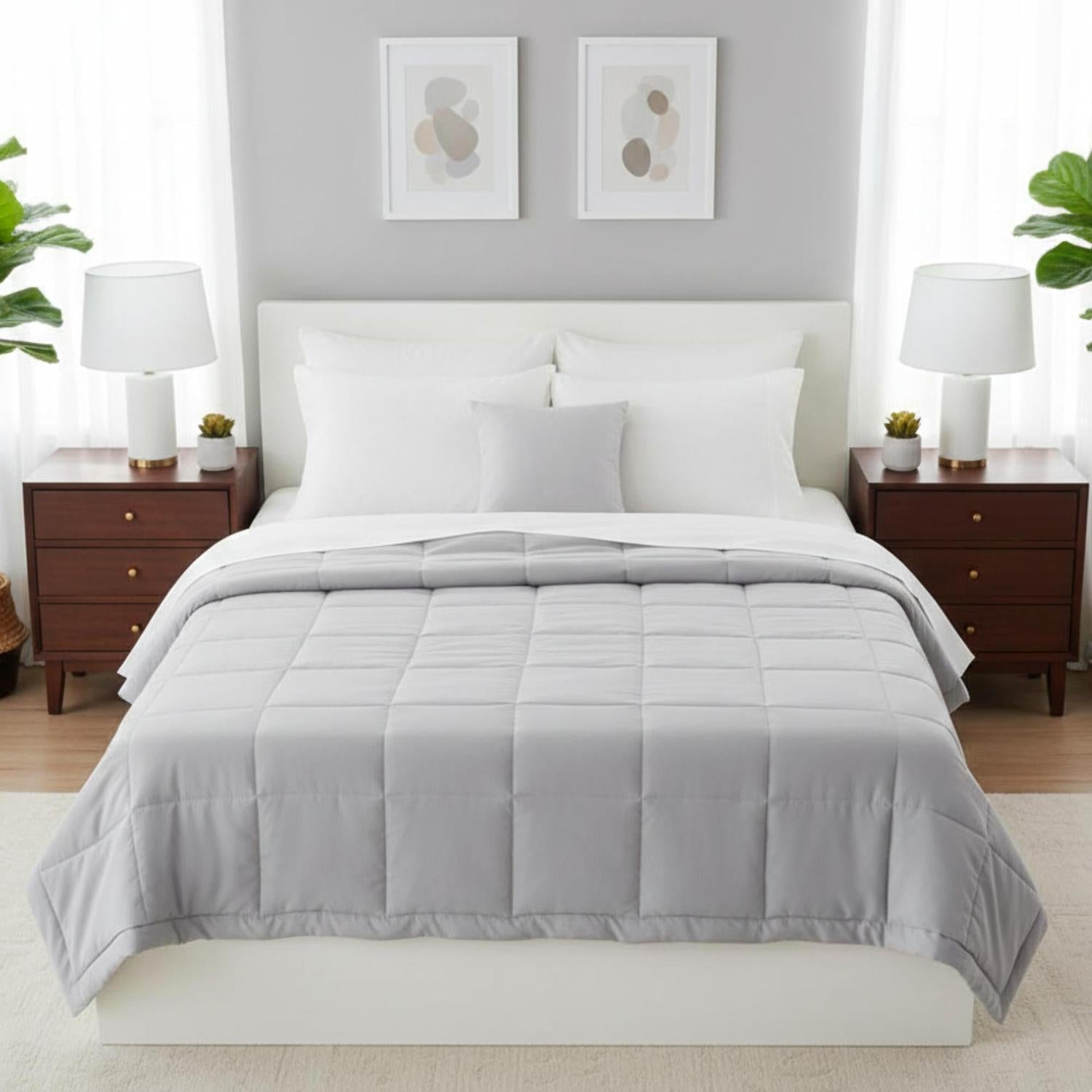 Light gray down alternative blanket quilt with embroidered square pattern on a white bed.