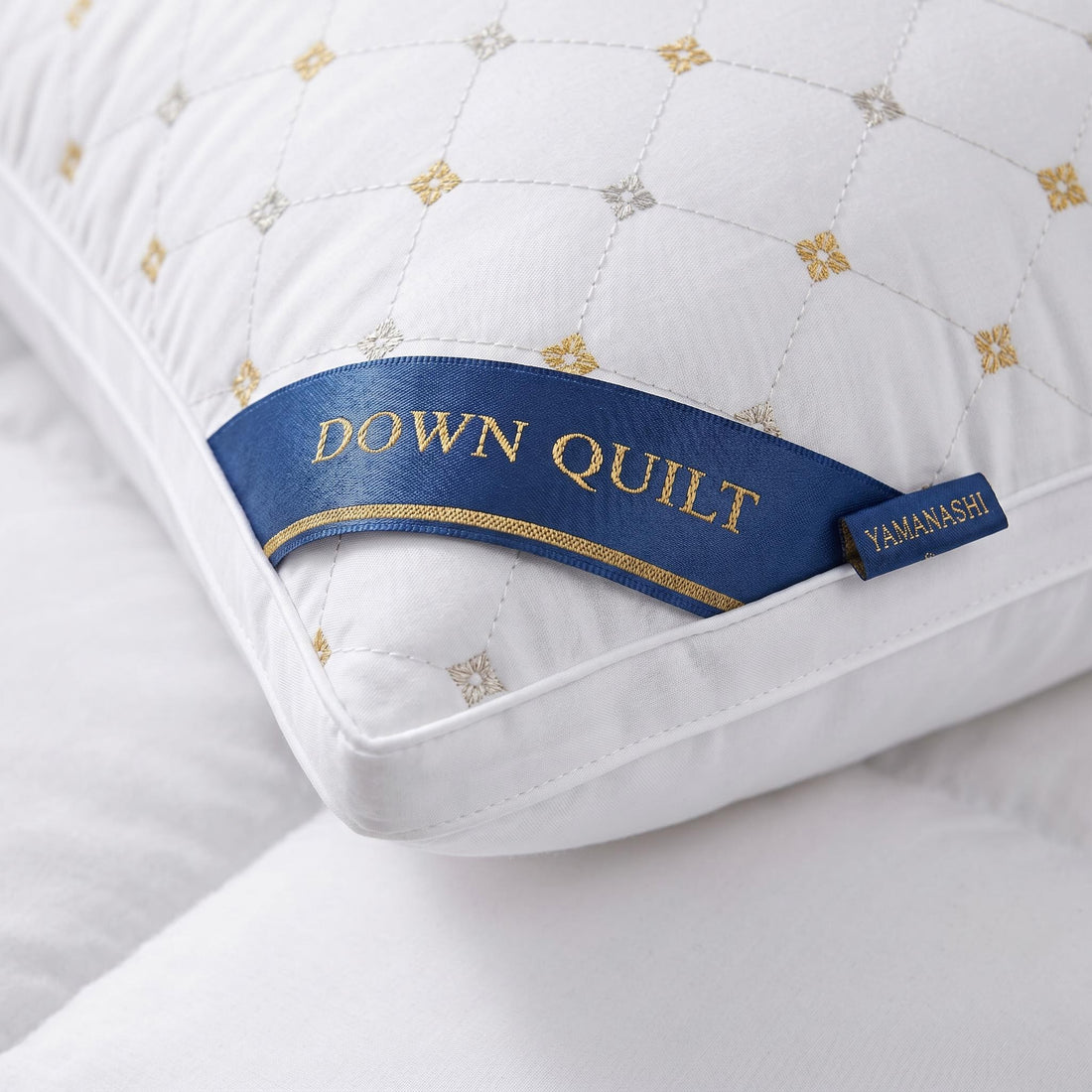 Woman in silk pajamas hugging a white queen-size down alternative pillow with gold star pattern in a modern bedroom.