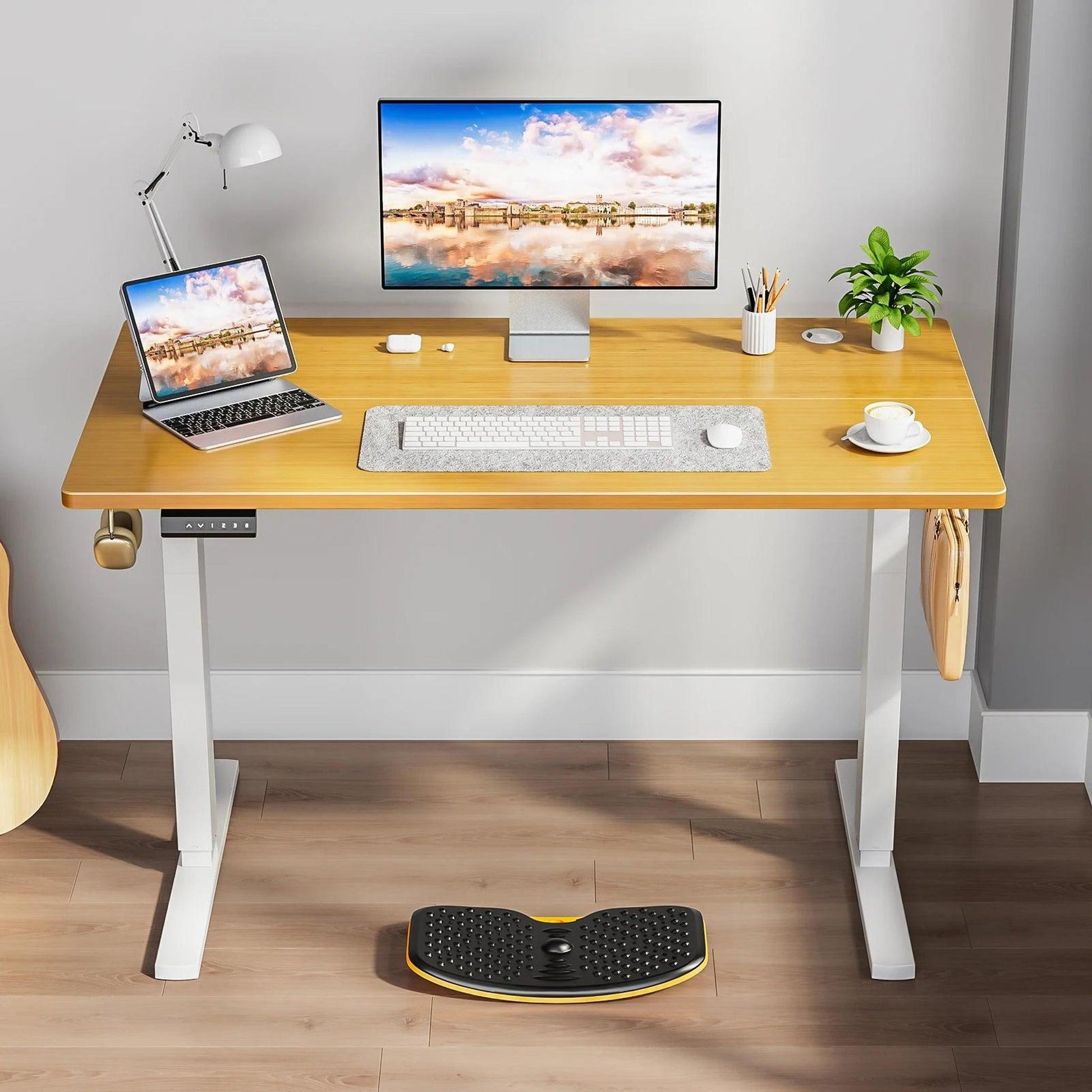 Electric adjustable standing desk with a light wood top and white T-shaped metal frame.