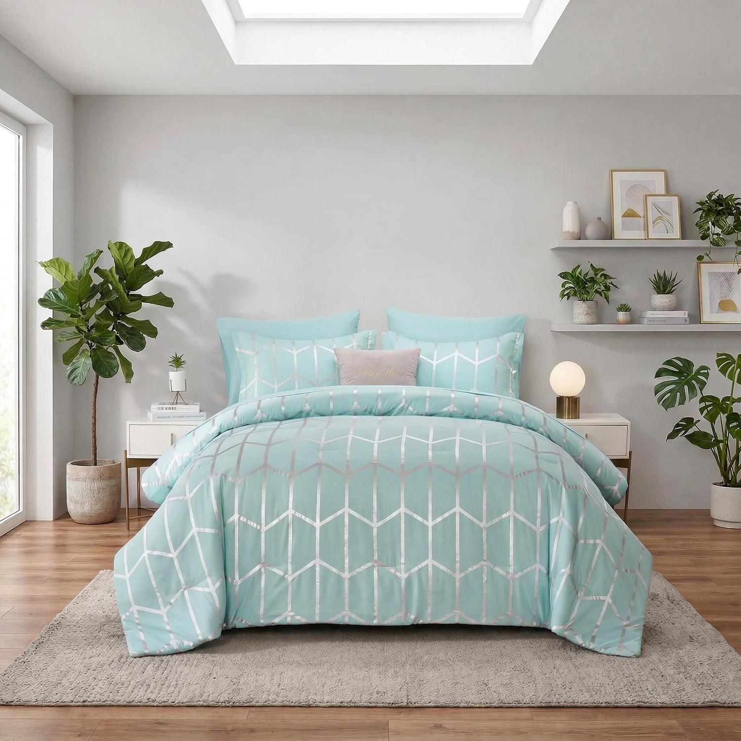 Aqua comforter set with silver geometric foil design, two shams, and decorative pillows on a bed.