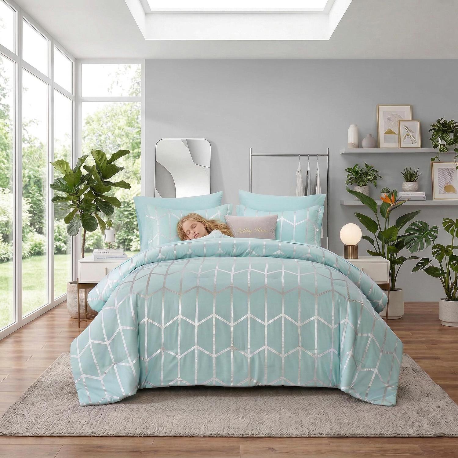 Light blue microfiber comforter set with silver geometric foil design on a bed in a bright bedroom.