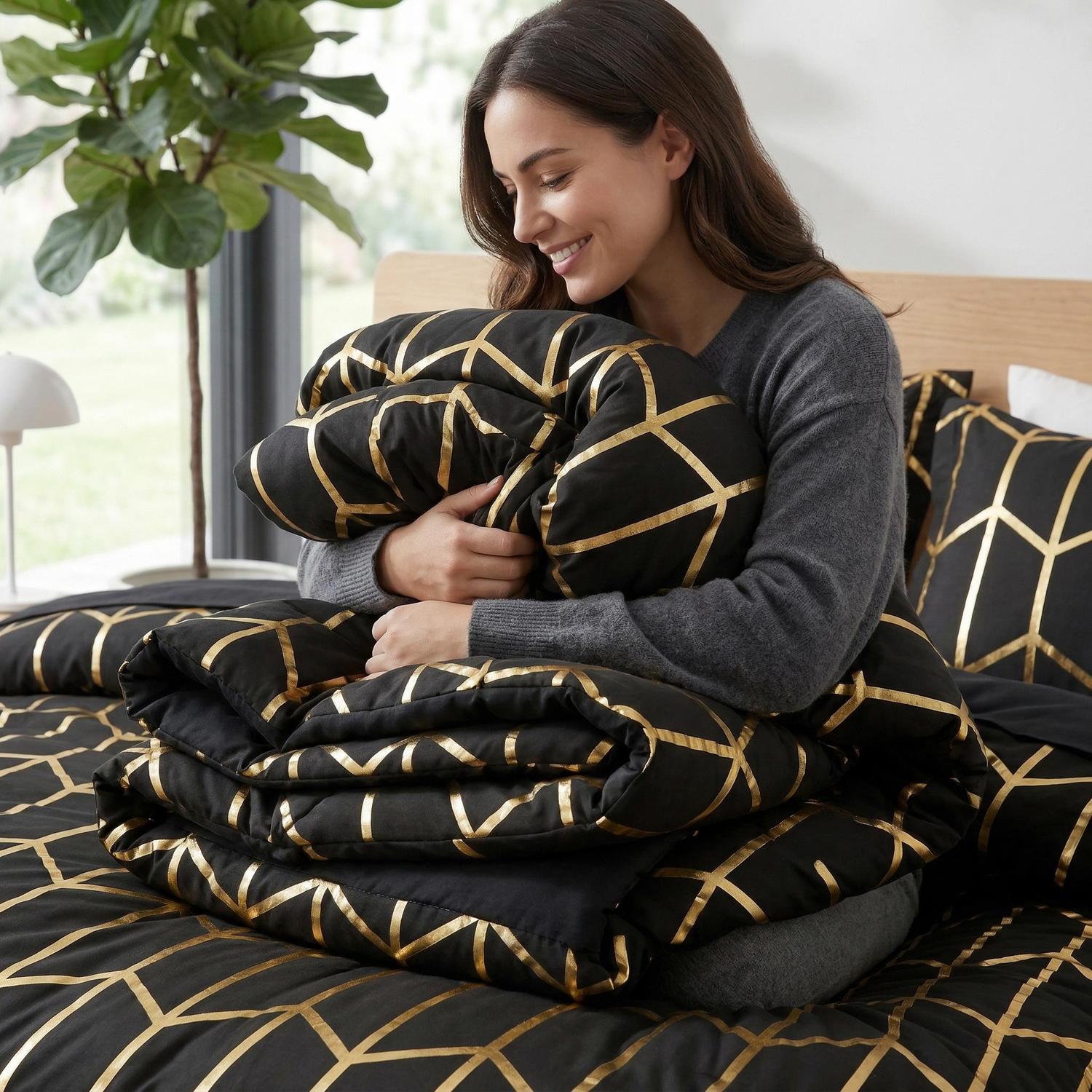 Woman hugging a black microfiber comforter set with a gold foil geometric design.