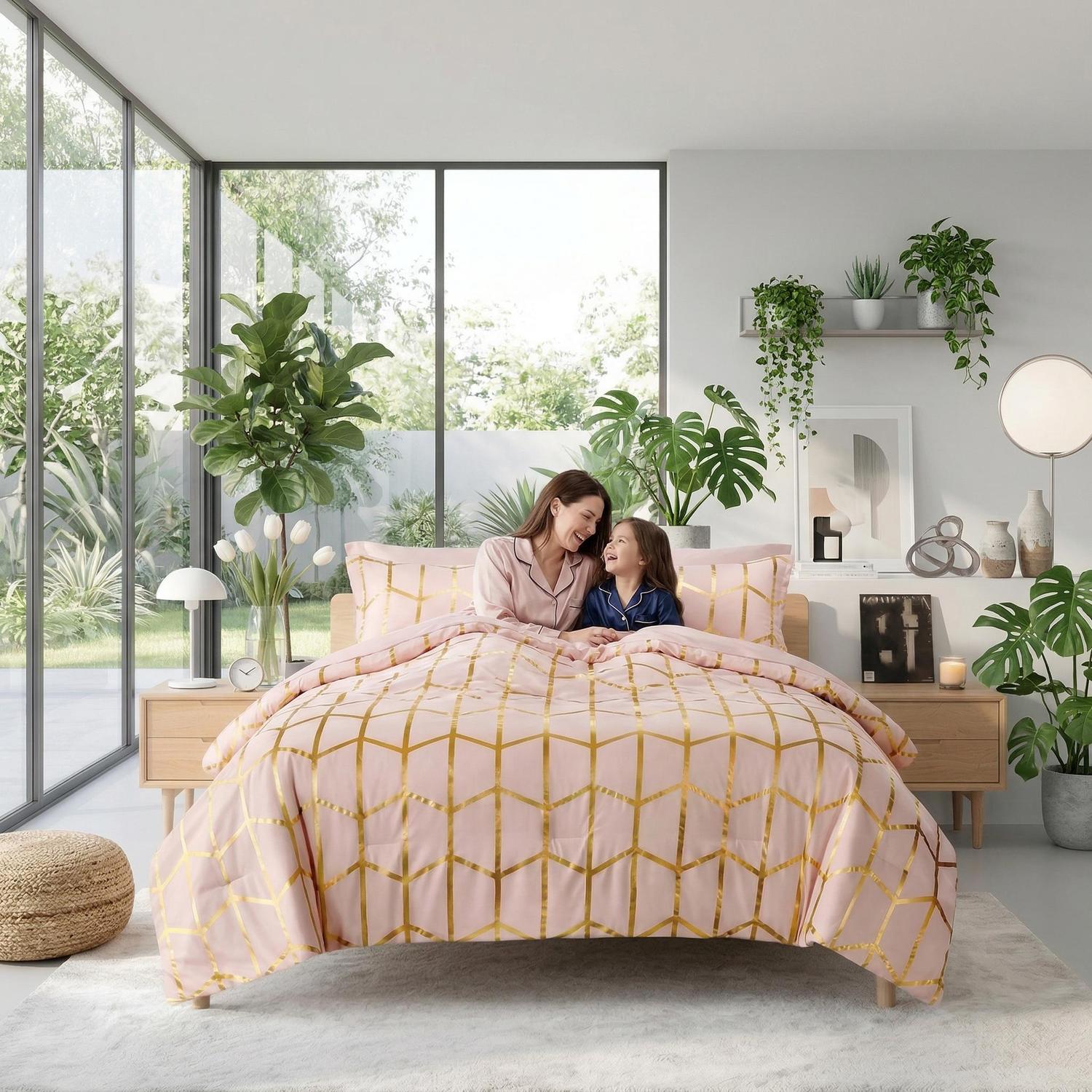 Pink comforter set with gold geometric foil design, brushed microfiber, on a bed with a mother and child.