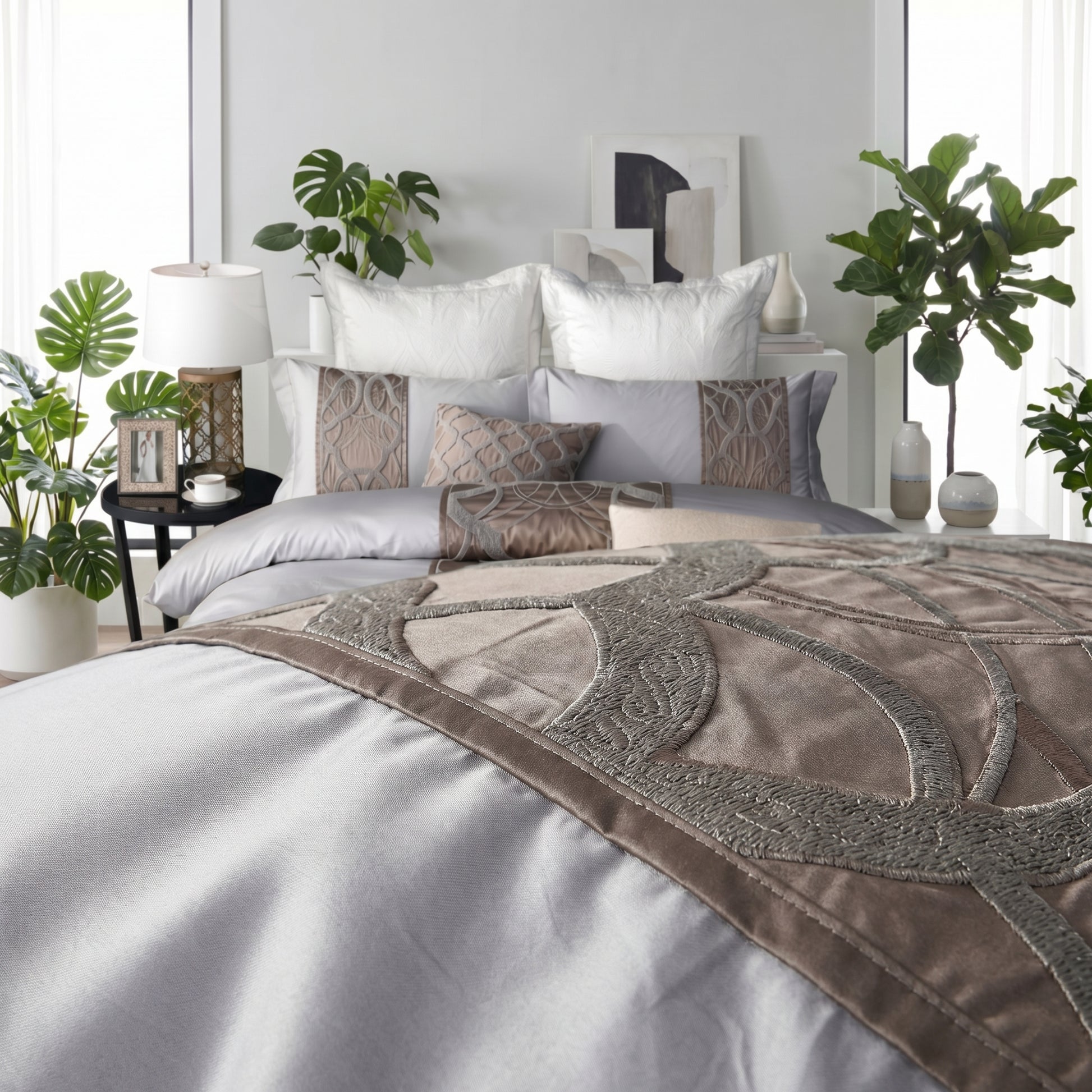 Elegant silvery-grey cotton bedding set with intricate embroidered detailing and decorative pillows.