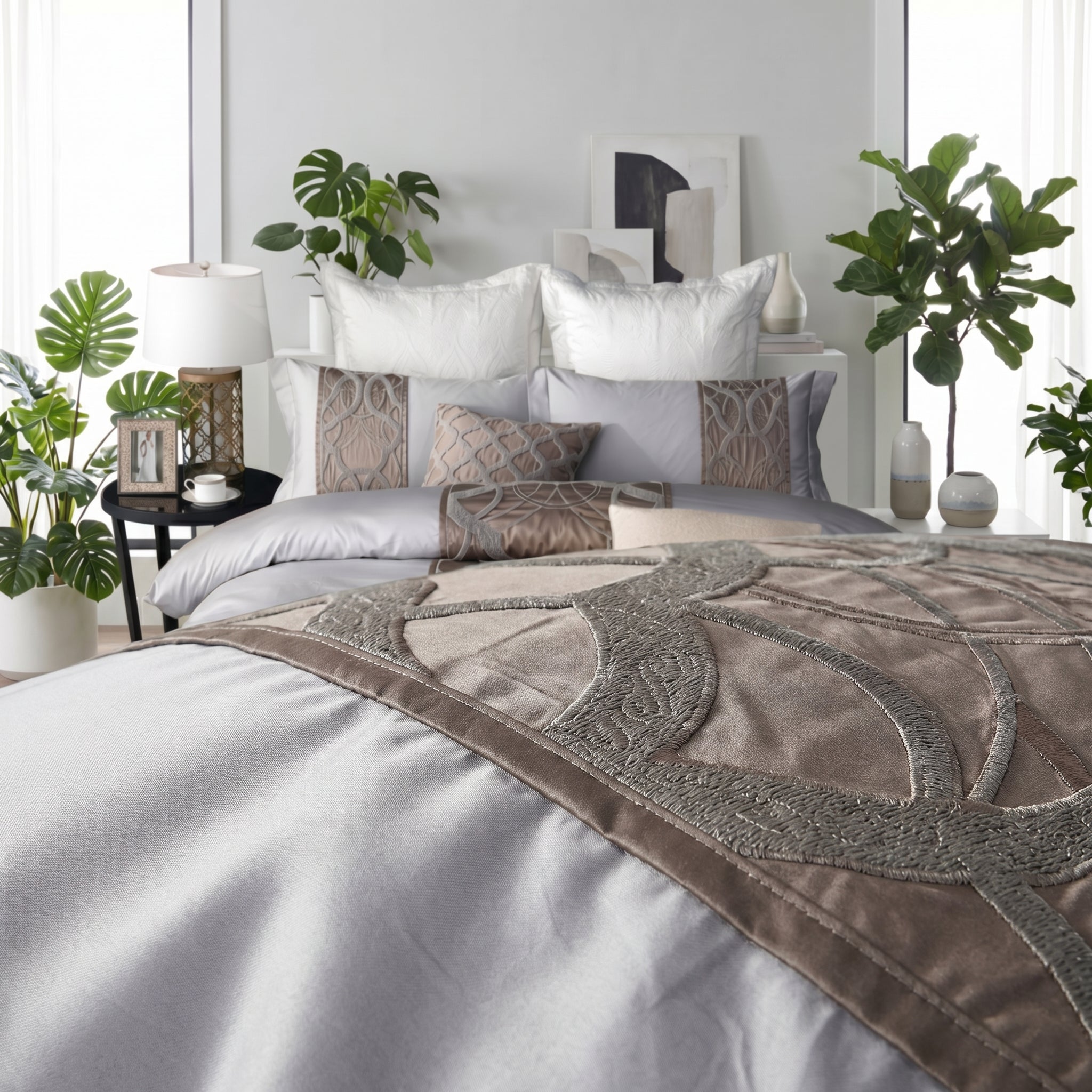 Elegant silvery-grey cotton bedding set with intricate embroidered detailing and decorative pillows.