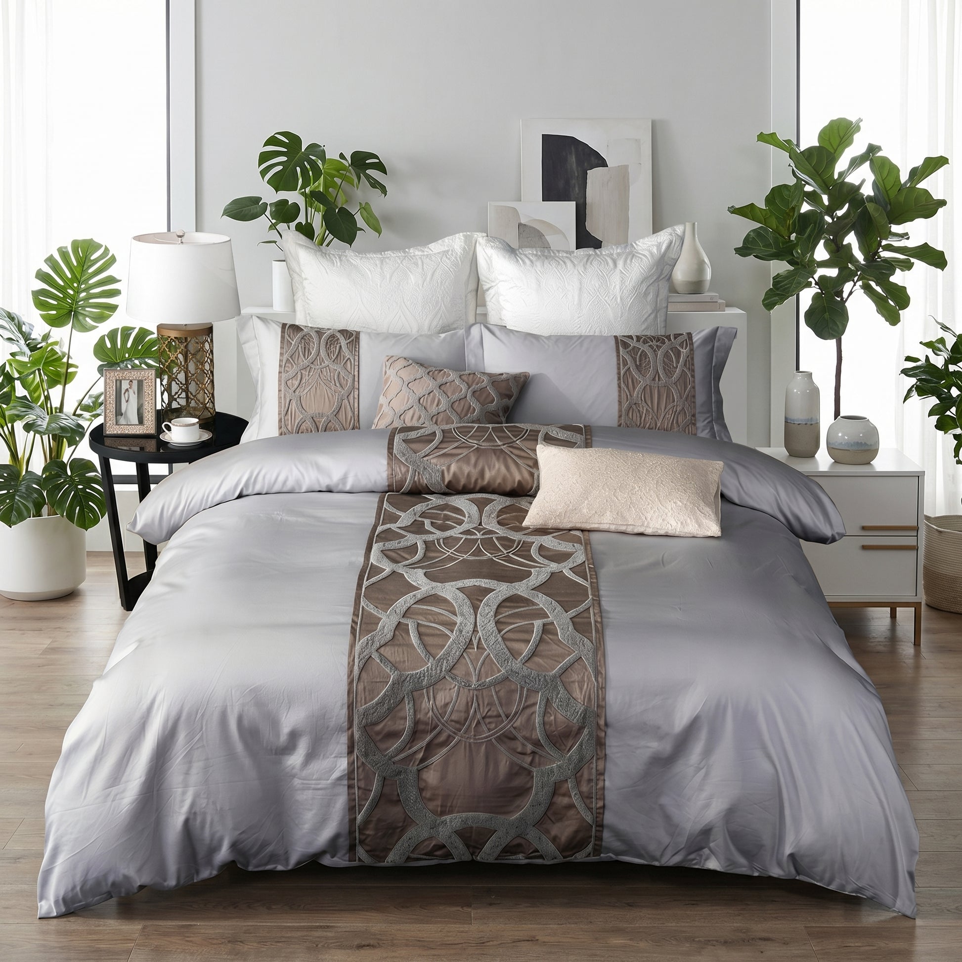 Elegant silvery-grey cotton bedding set with intricate brown embroidery and decorative pillows.