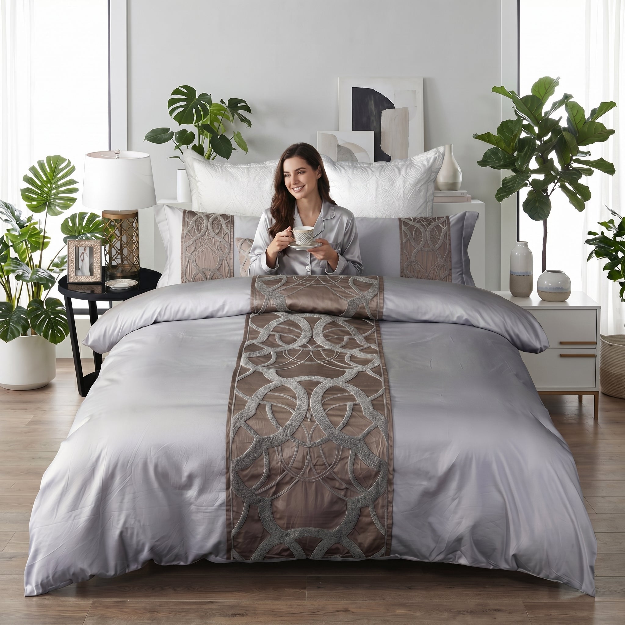 Elegant silvery-grey cotton bedding set with intricate brown embroidery and decorative pillows.