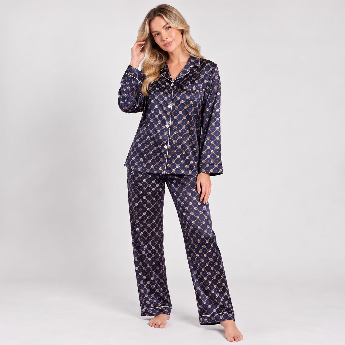 Woman wearing a navy blue mulberry silk pajama set with a geometric print, notched collar, and white piping trim.