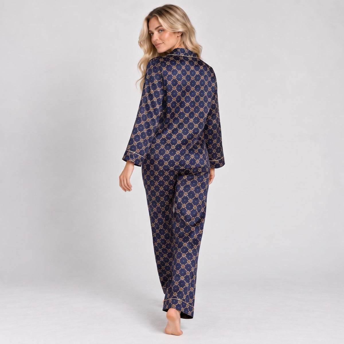 Woman wearing a navy blue mulberry silk pajama set with a geometric print, long sleeves, and contrast piping.