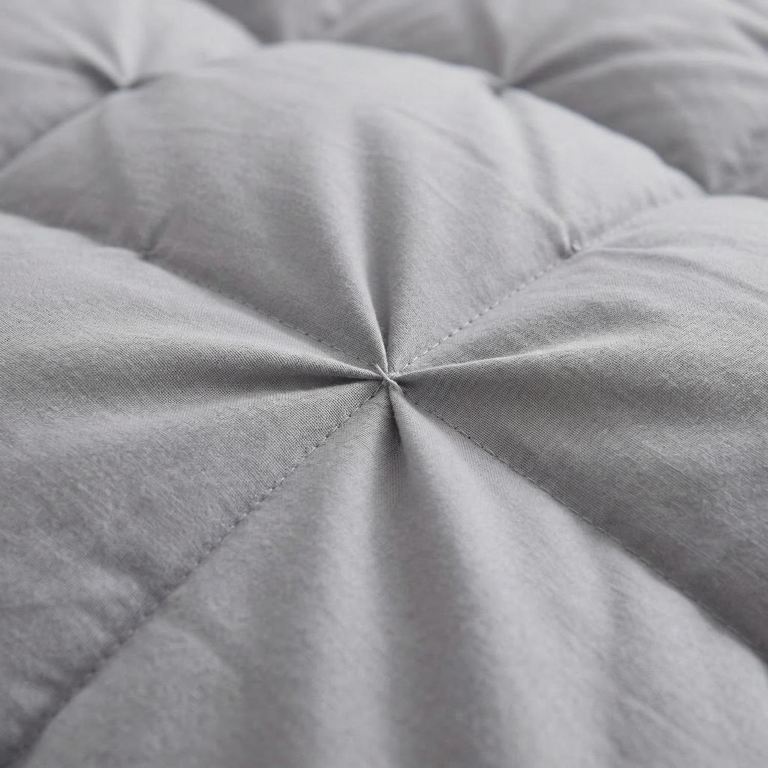 Close-up of a gray 100% cotton goose down comforter with an elegant twist flower pattern.