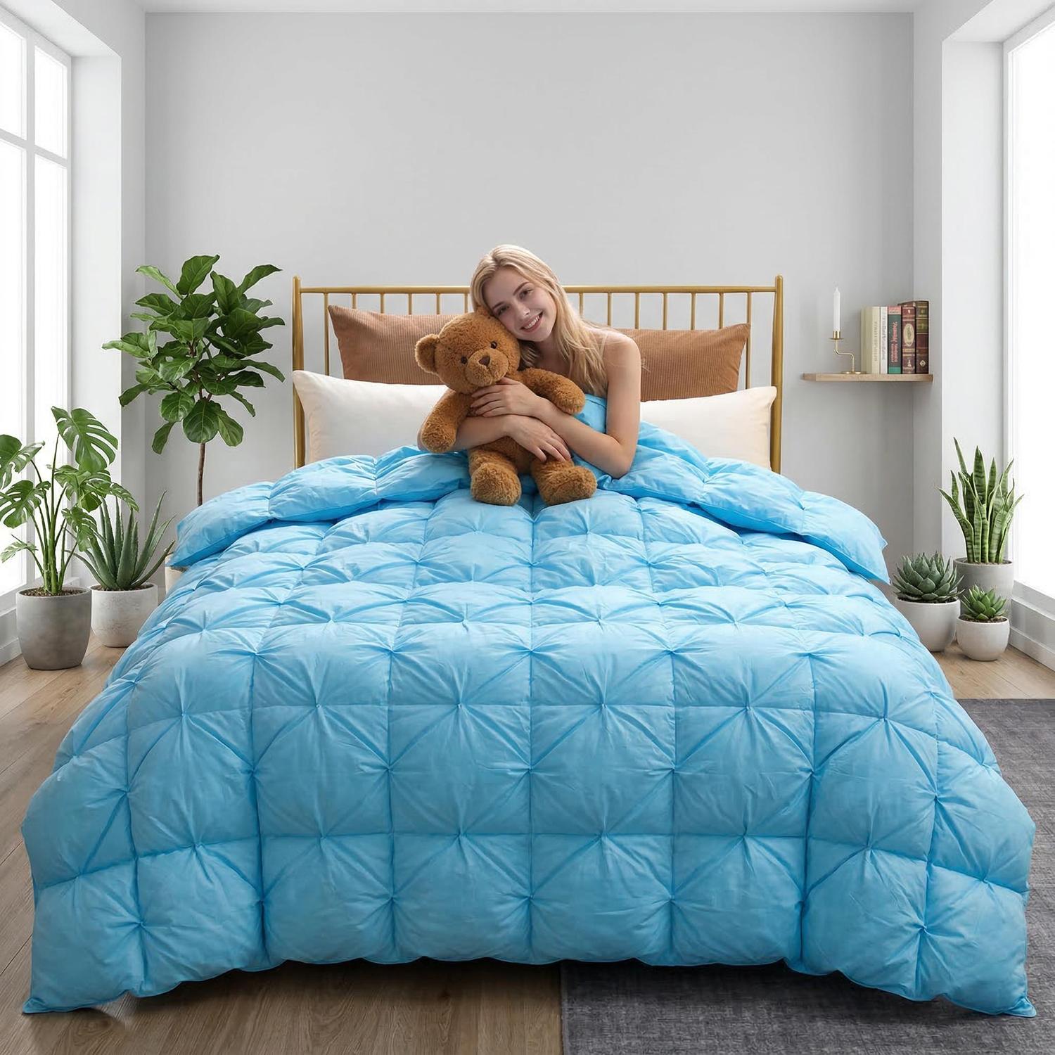 Smiling woman on bed with a blue goose down quilt comforter featuring a twist flower design.