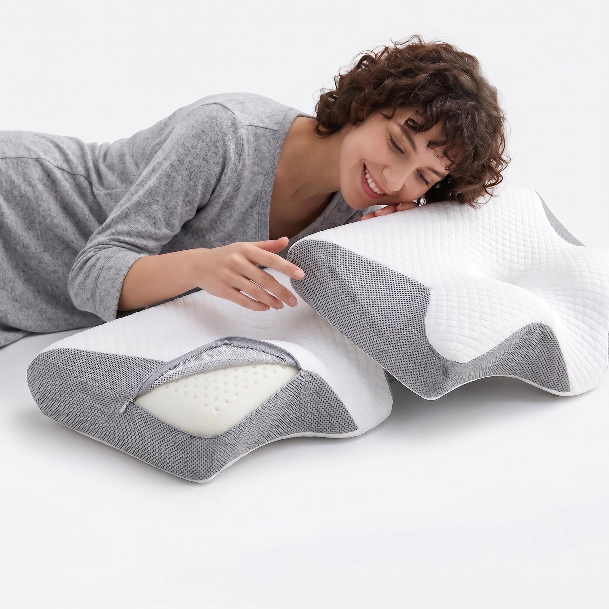 Smiling woman with a white and gray butterfly-shaped memory foam neck pillow, one unzipped to show the foam.