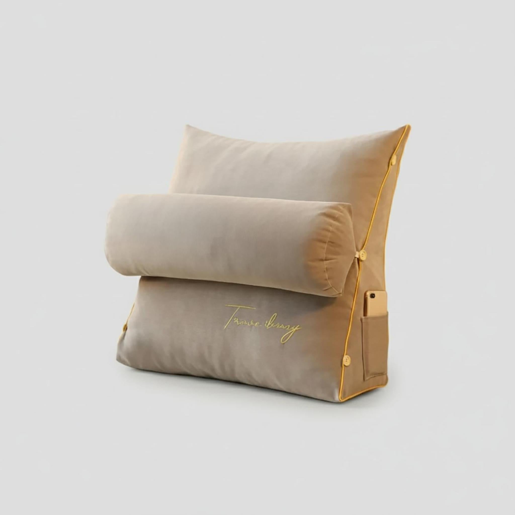 Beige ergonomic lumbar support pillow with a cylindrical bolster, gold trim, side pocket, and embroidered text.