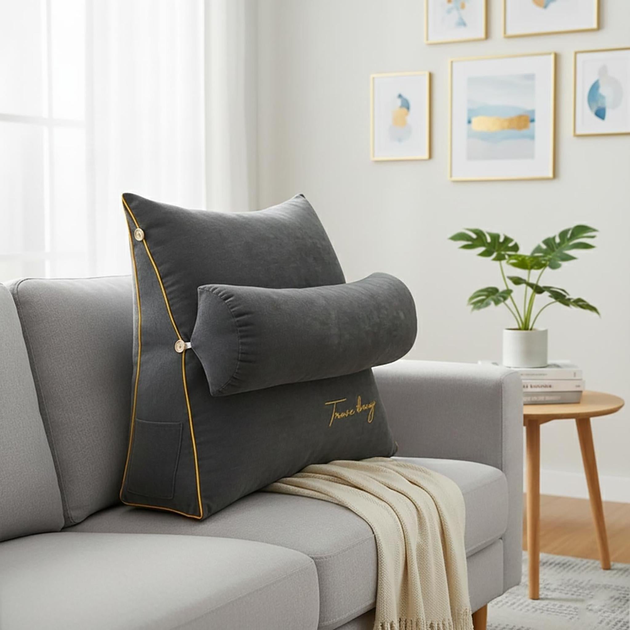 Dark gray ergonomic wedge pillow with a removable bolster and yellow trim on a light gray sofa.