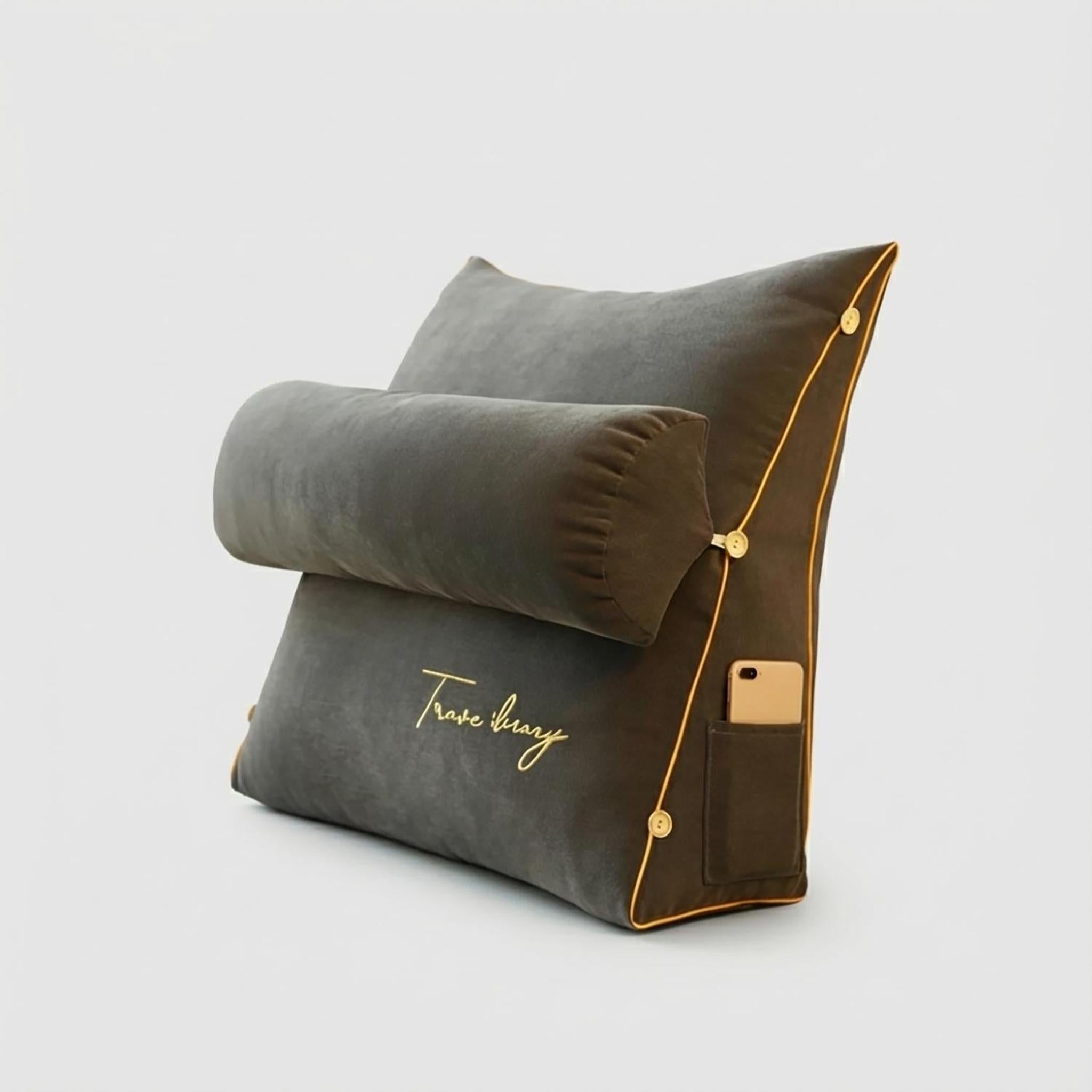 Dark gray ergonomic wedge pillow with a bolster, gold piping, side pocket holding a phone, and "Travel diary" embroidery.