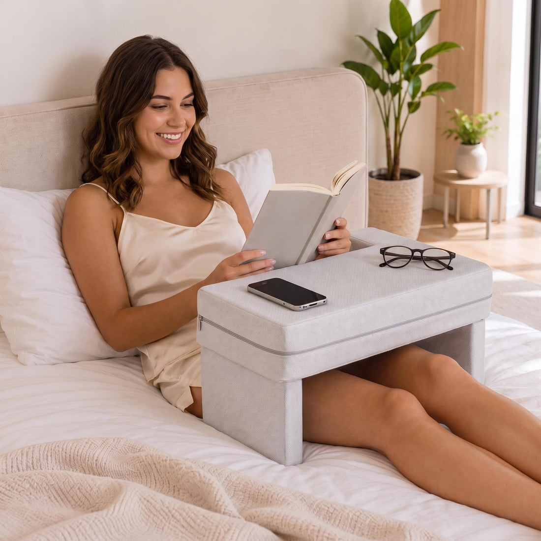 Woman using a grey ergonomic memory foam lap desk with armrest grooves and a phone holder while working on a laptop.