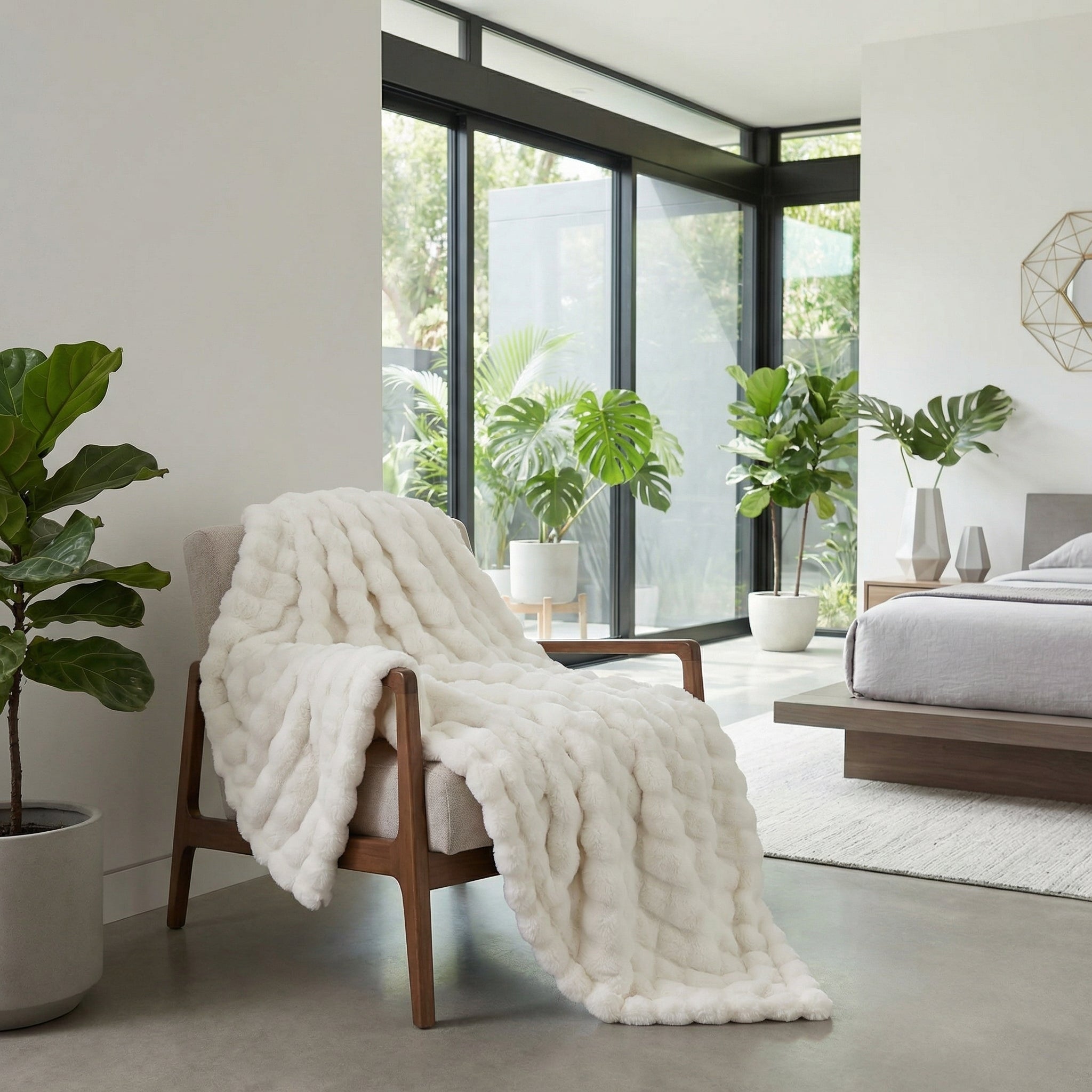 Cream faux fur striped throw blanket draped over a modern wooden armchair in a bright bedroom.