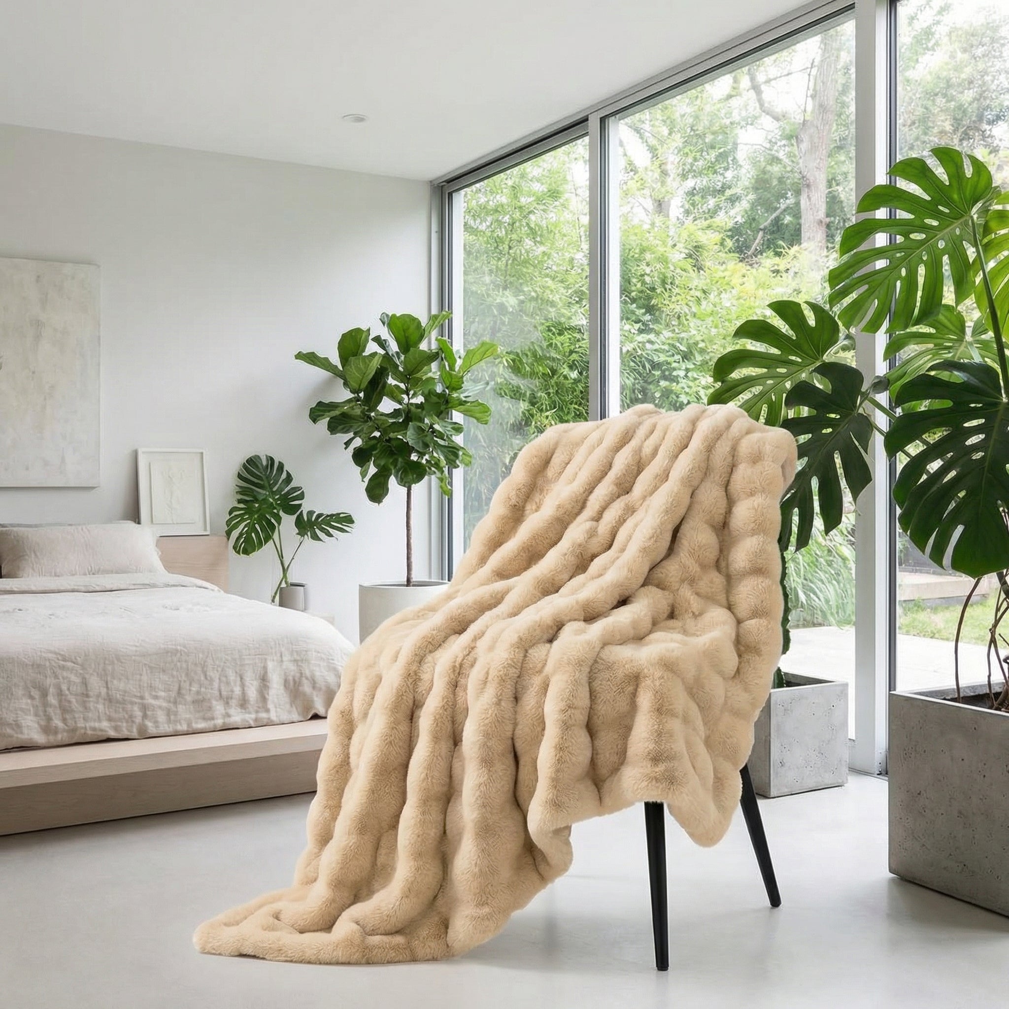 Plush beige faux fur striped throw blanket draped over a black chair in a modern bedroom.