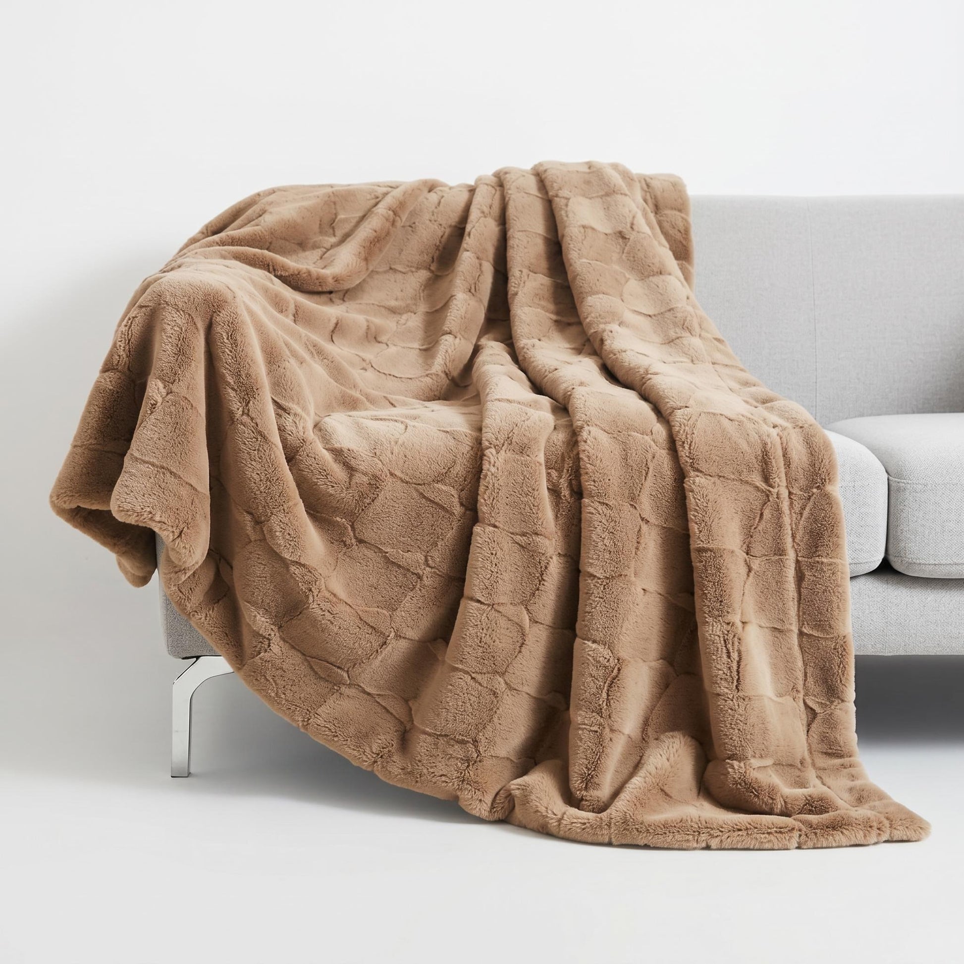 Soft, plush brown faux fur throw blanket draped over a grey sofa, showcasing its rich texture and elegant design.