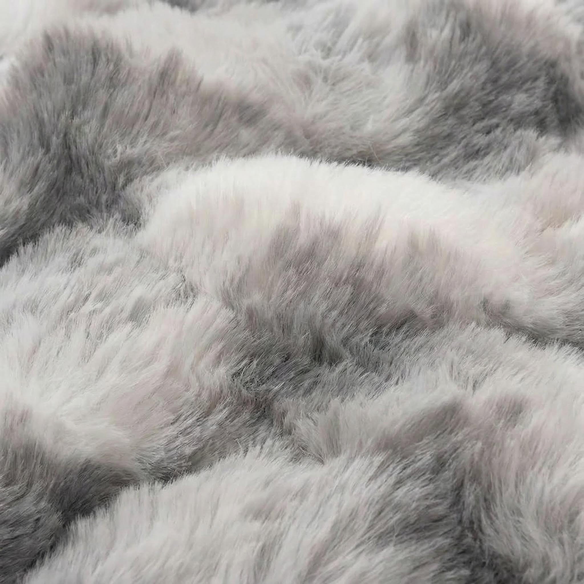 Soft, reversible faux rabbit fur throw blanket in shades of light gray and white, showcasing its plush texture.