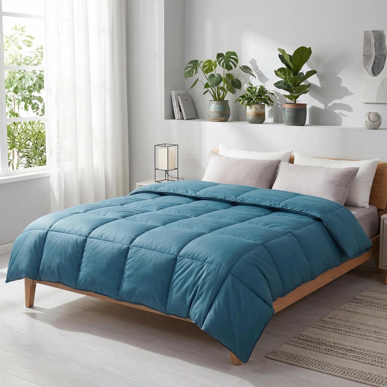 Blue cotton quilt comforter with goose down filling on a wooden bed.
