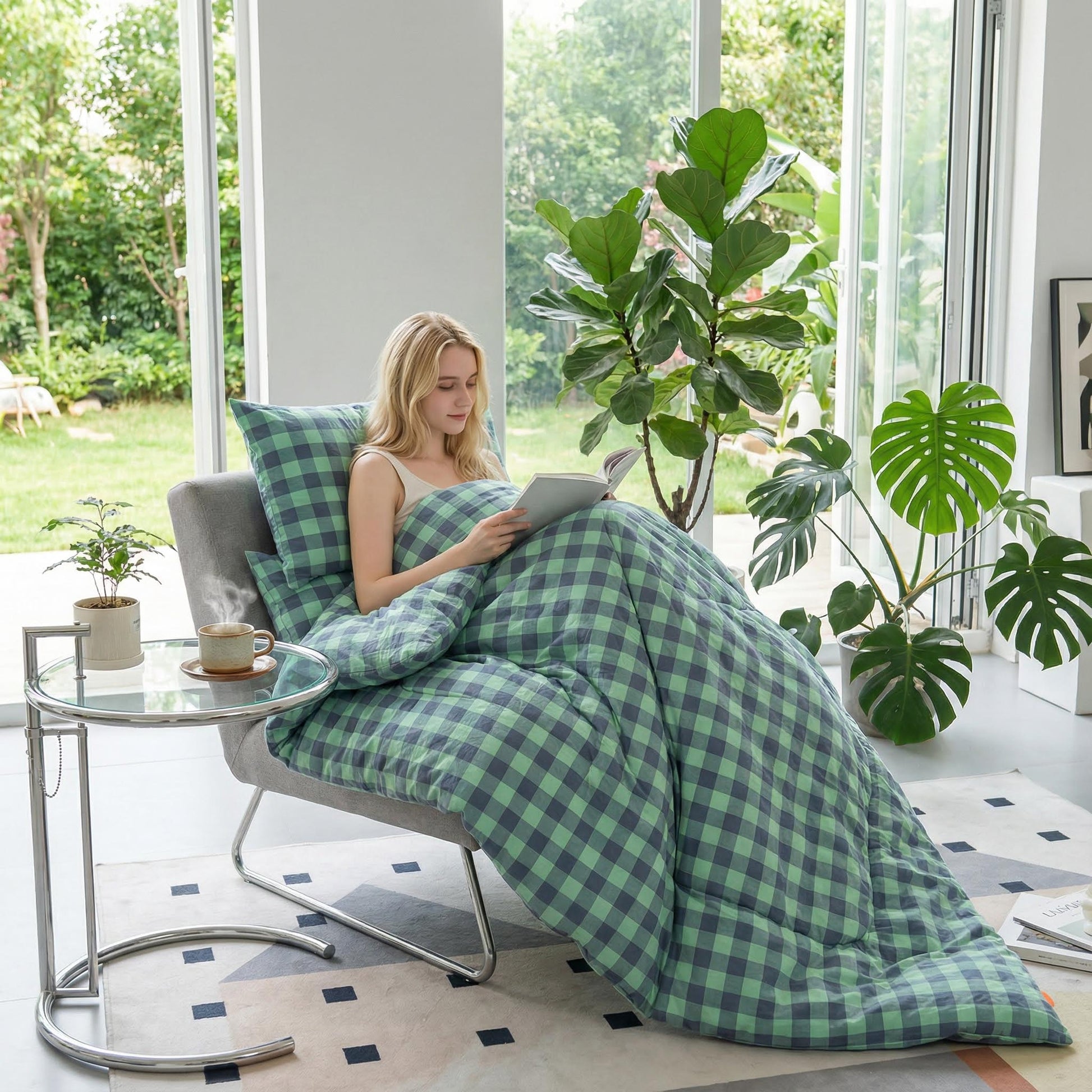 Young woman relaxing in a chair, covered by a soft green and grey plaid flannel fleece blanket.