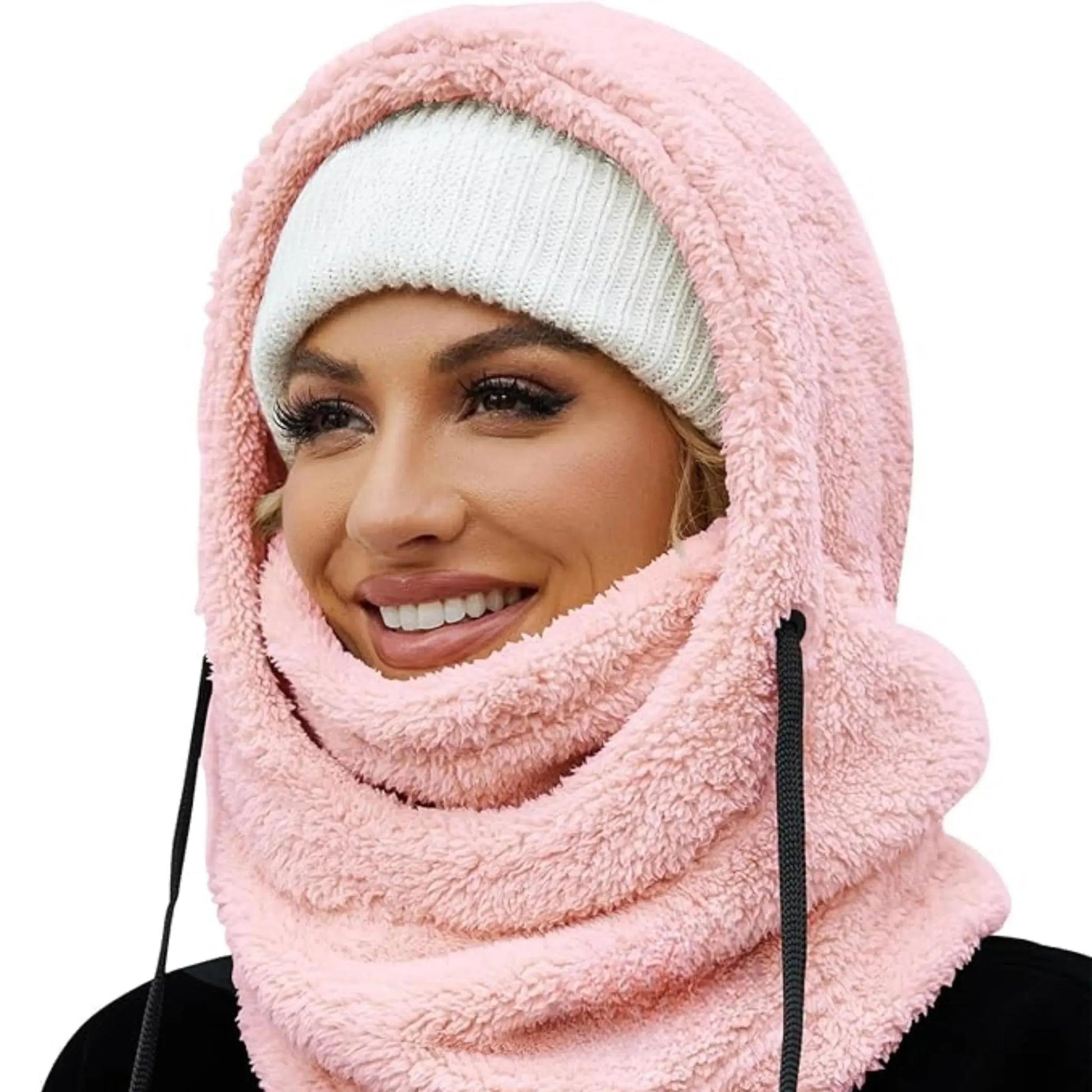 Woman wearing a pink plush fleece hooded beanie scarf with a white knit beanie.