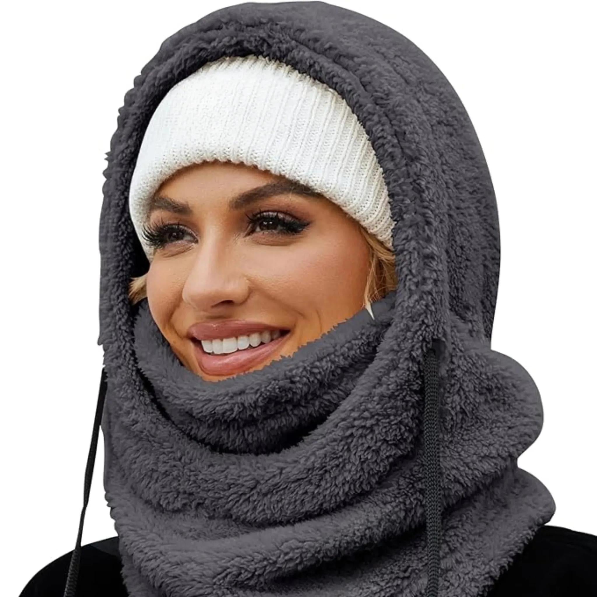 Woman wearing a grey plush fleece hooded beanie scarf over a white knit beanie.
