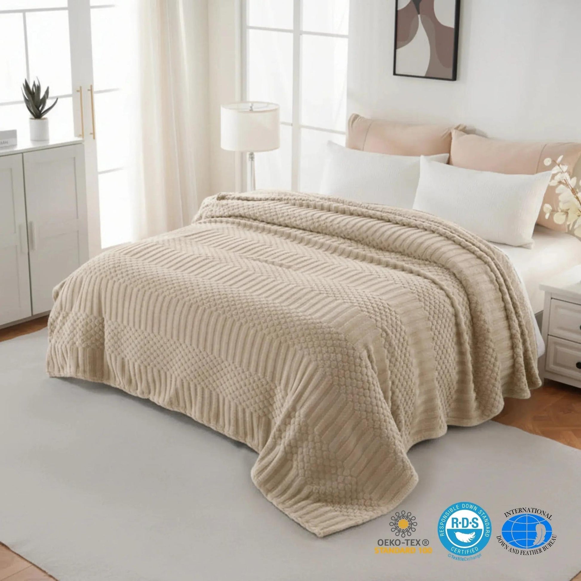 Soft beige 50x70 inch fleece throw blanket with textured chevron and dot patterns draped on a bed.