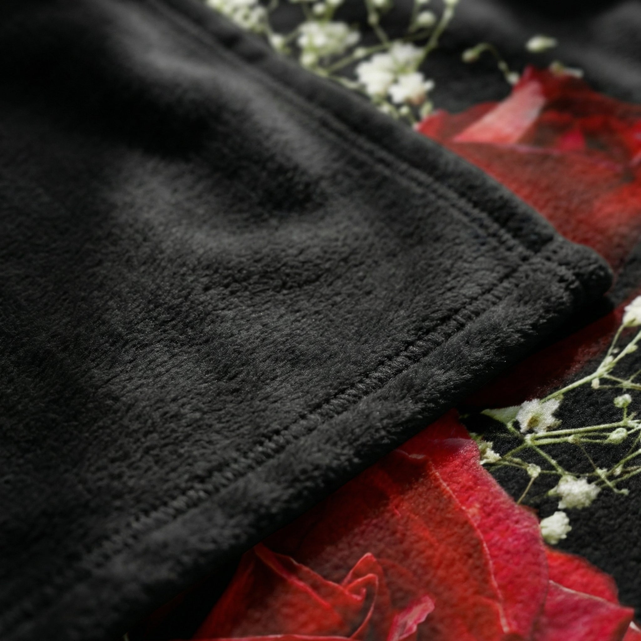 Soft black fleece blanket with vibrant 3D red roses and white babysbreath floral print.