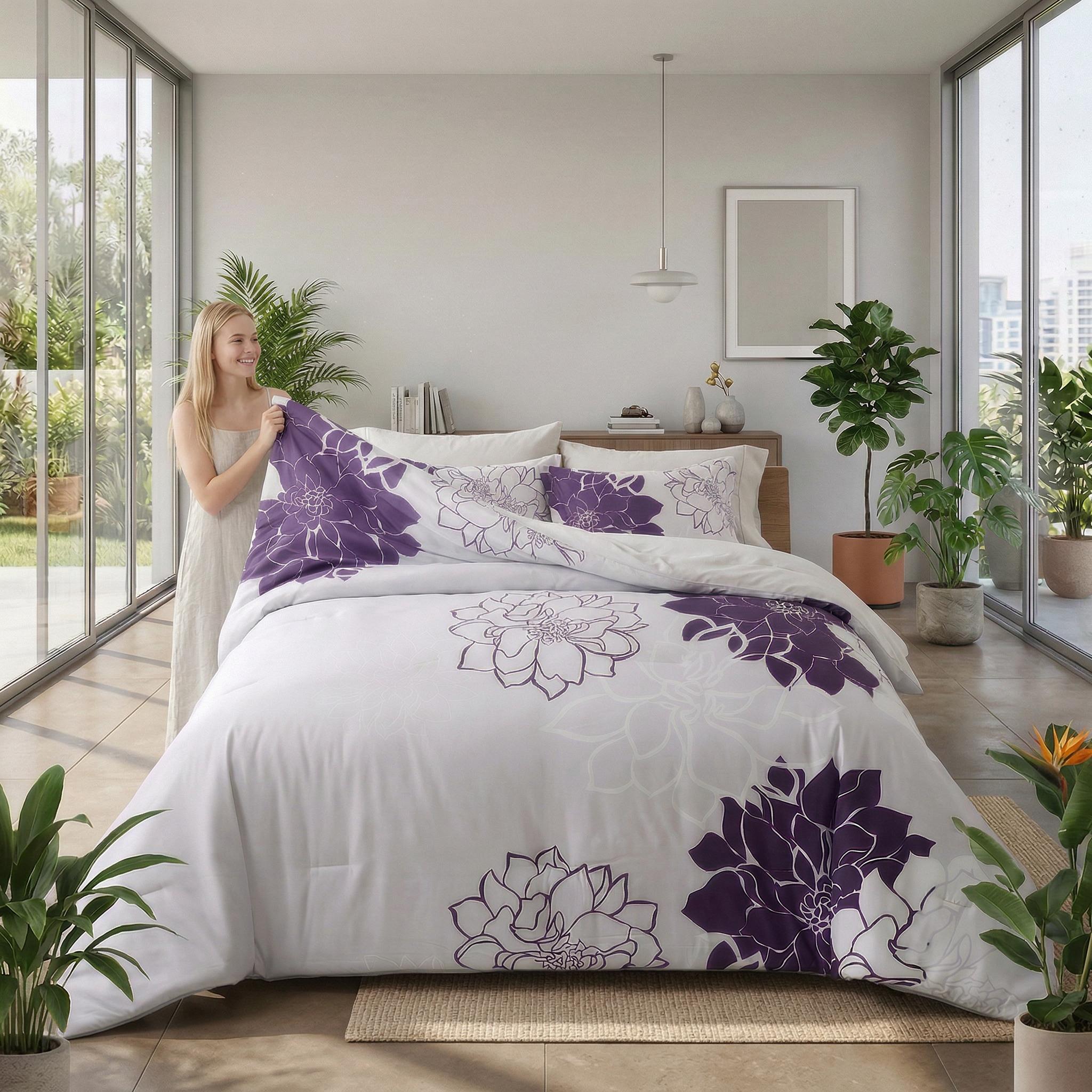 Woman holding a white microfiber floral bedding set with bold purple dahlia patterns.