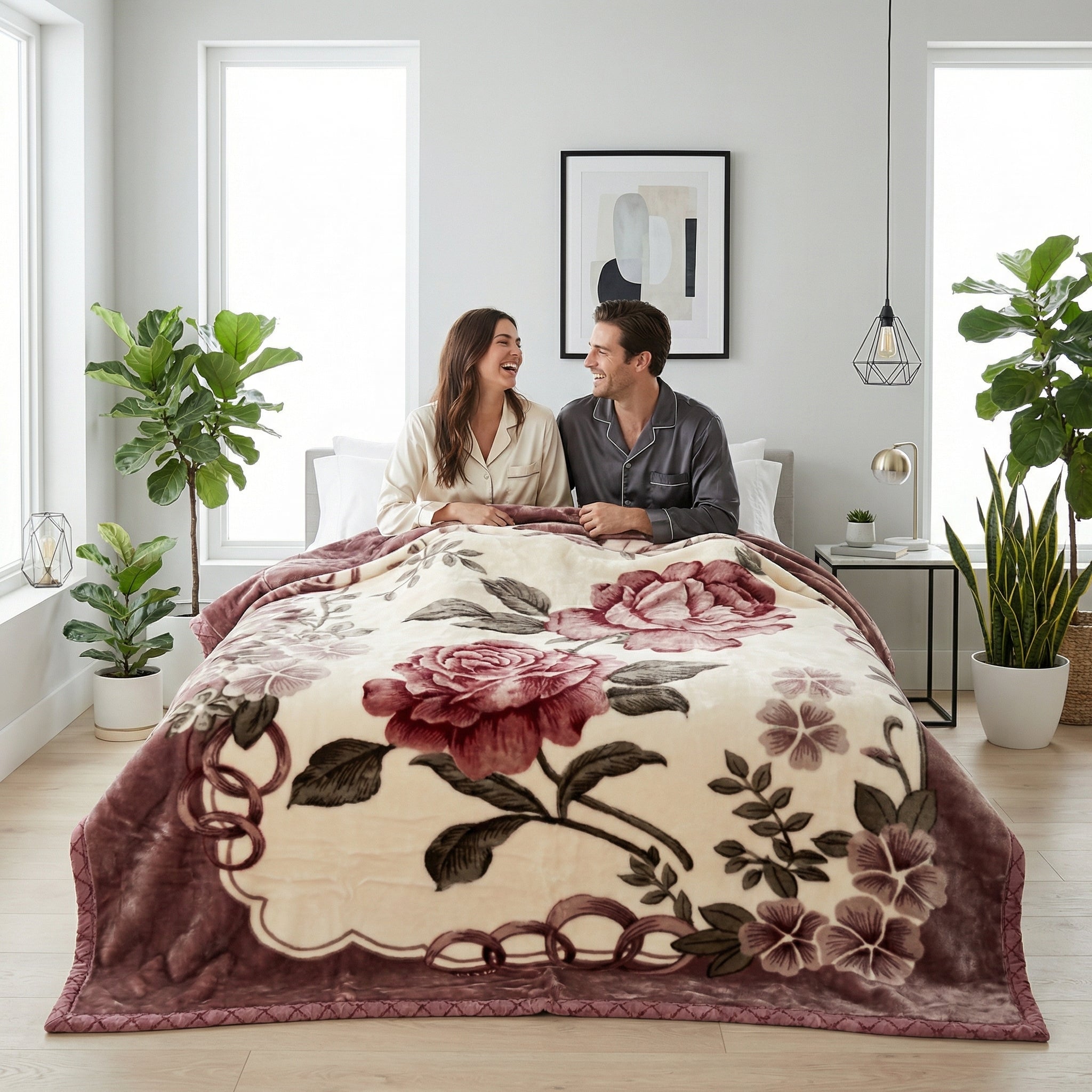 Cream microfiber fleece throw blanket with large red and purple floral design on a bed with a couple.