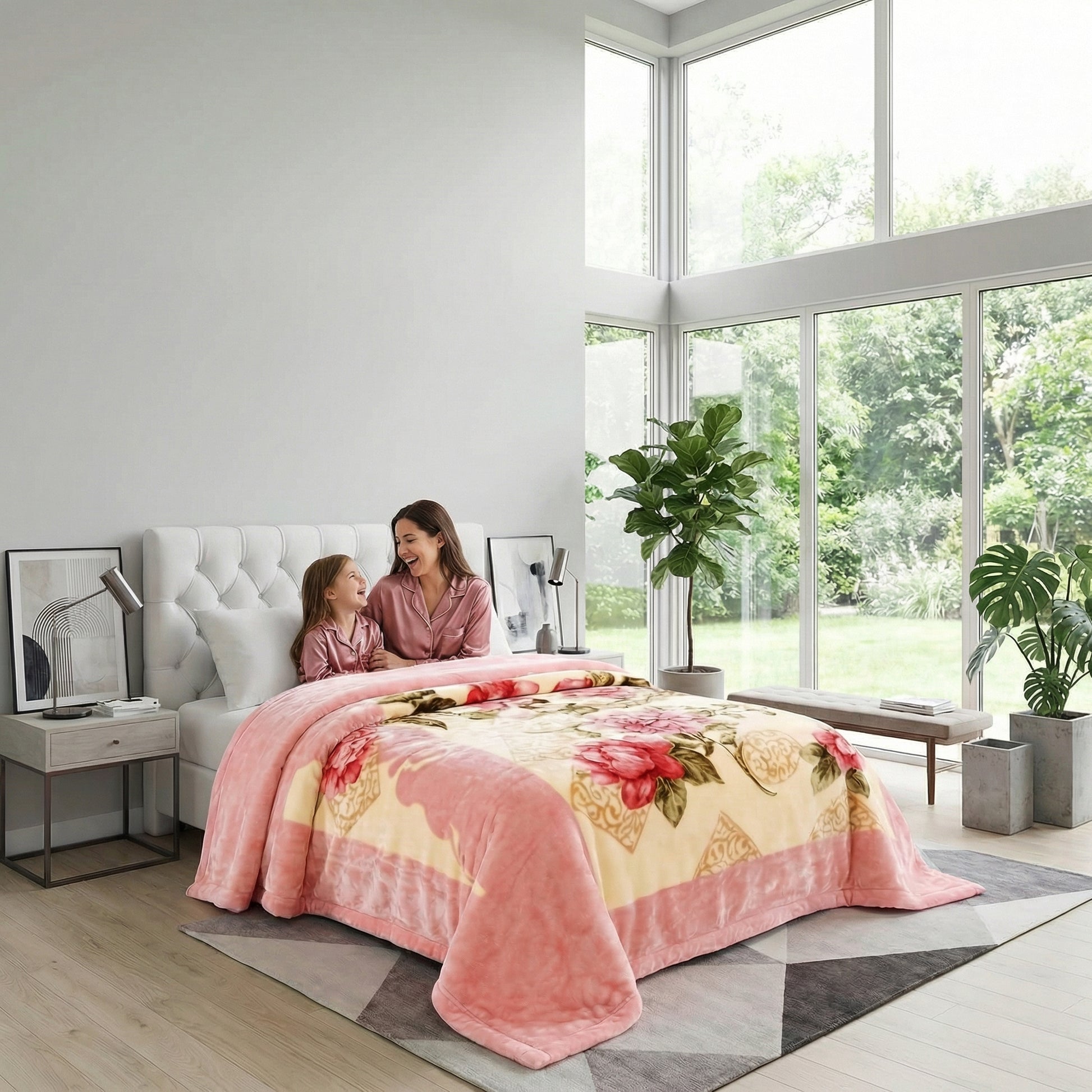 Pink and cream floral microfiber fleece throw blanket on a bed with a woman and child.