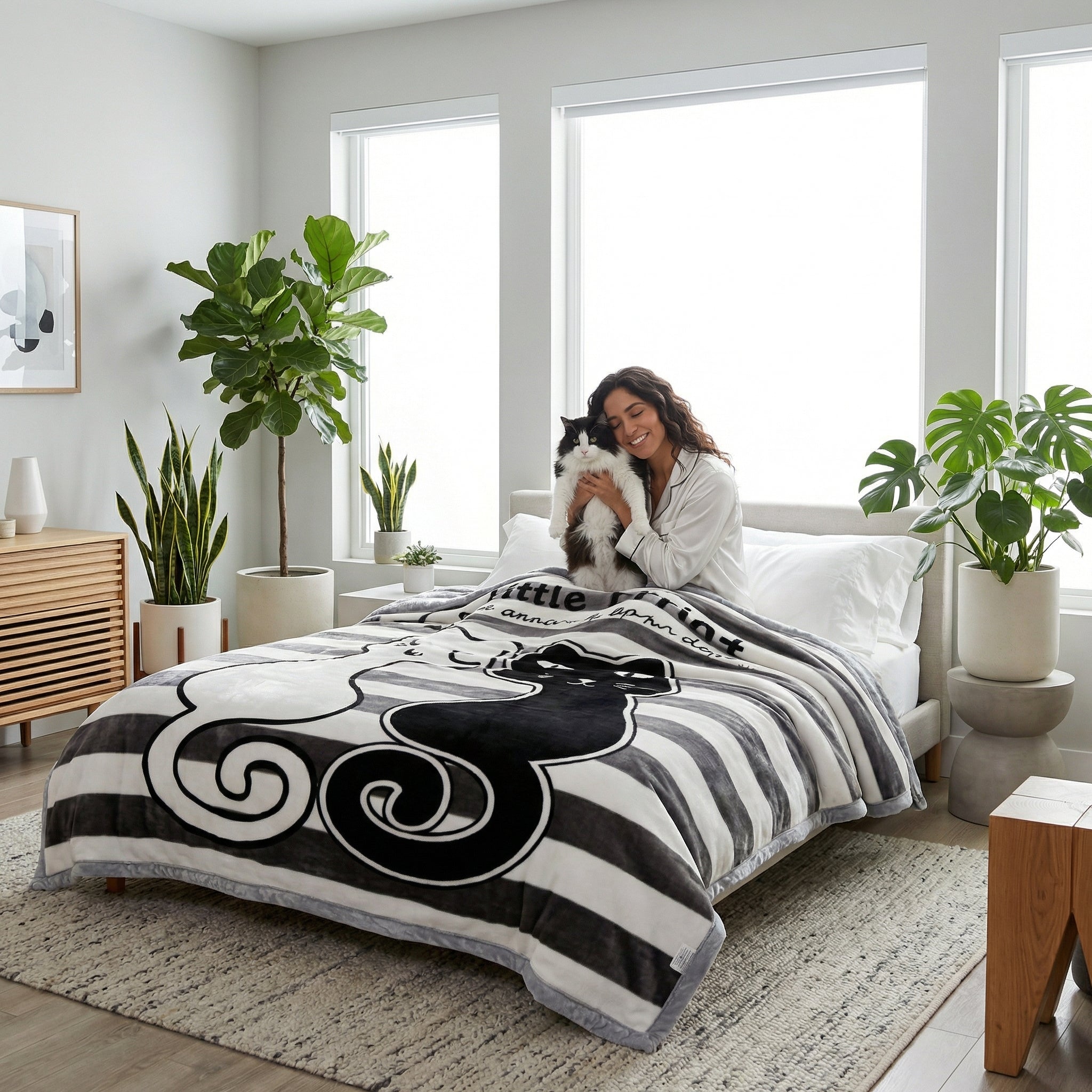 Woman on bed with black and white striped microfiber fleece blanket featuring a cat design.