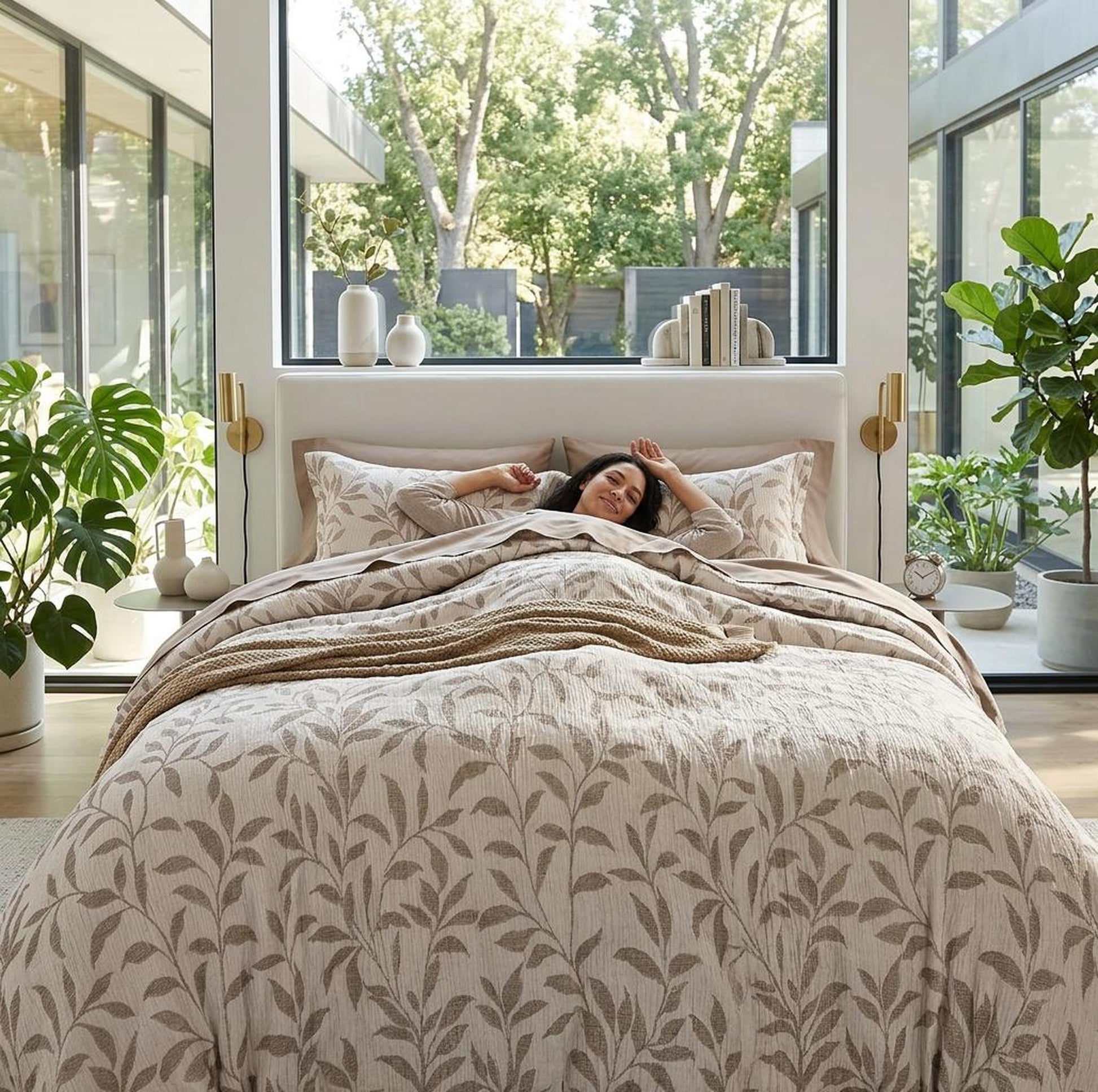 Elegant beige floral duvet cover set with a woman relaxing in a modern, bright bedroom.