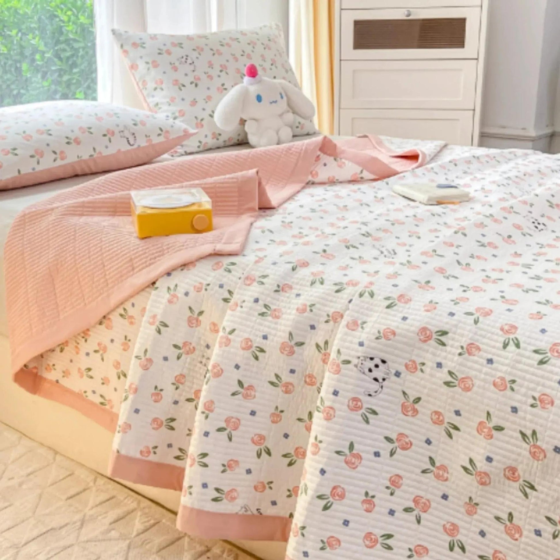 White microfiber quilt bedding set with pink floral pattern and solid pink trim.