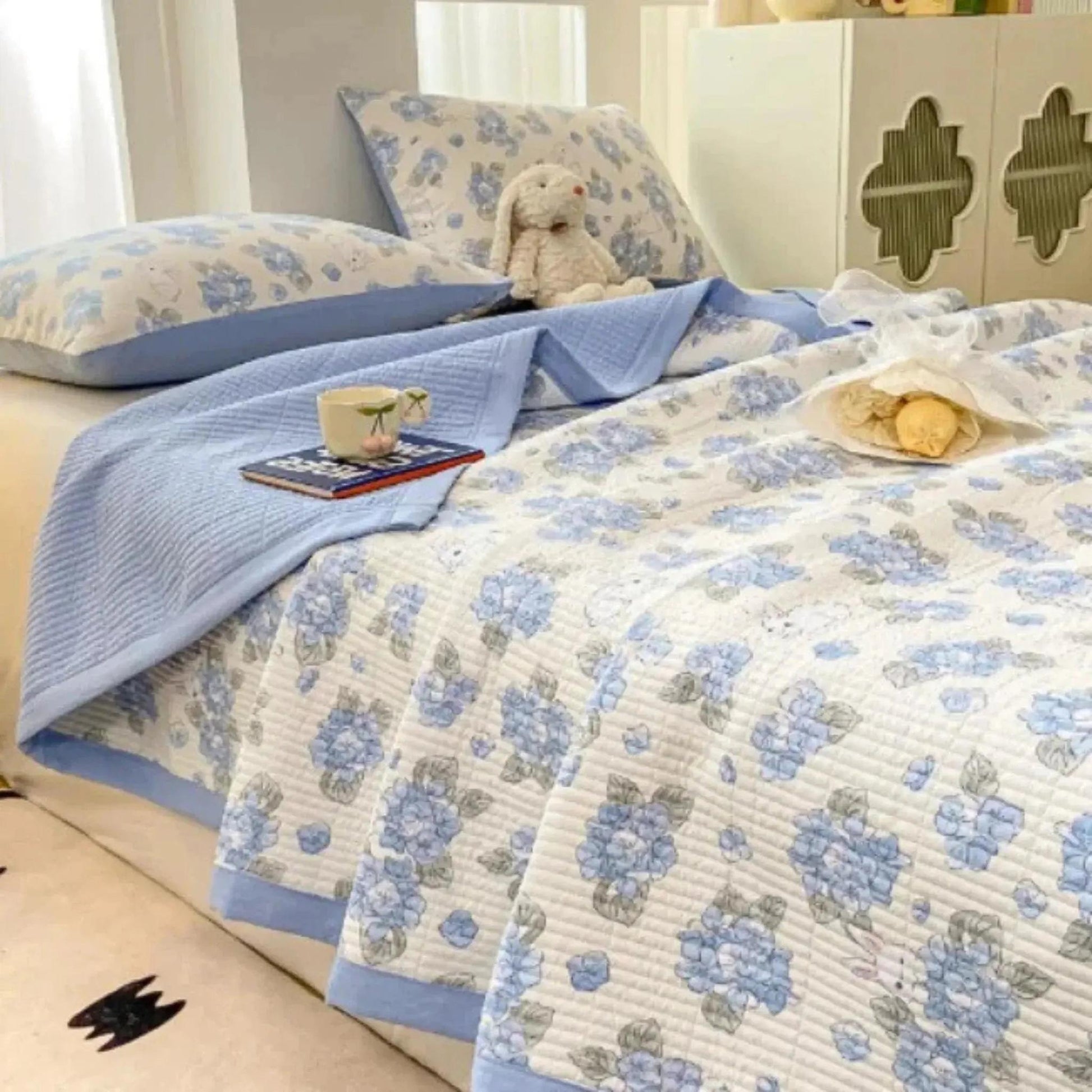 Floral microfiber quilt bedding set with blue flowers, light blue trim, and matching pillows.