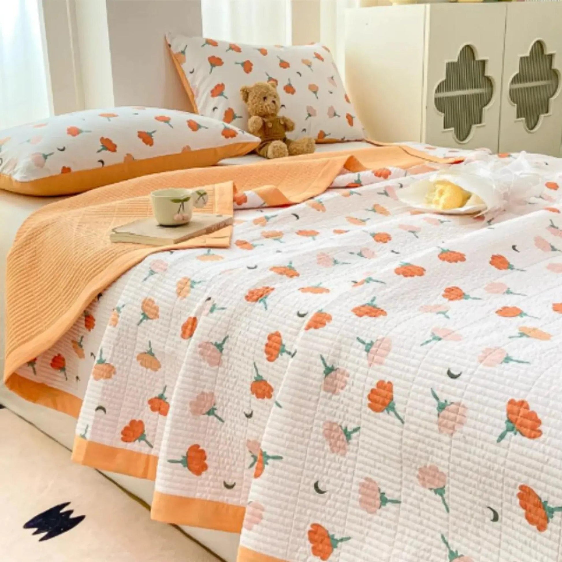 White microfiber quilt bedding with orange floral pattern, solid orange reverse, and matching pillowcases.