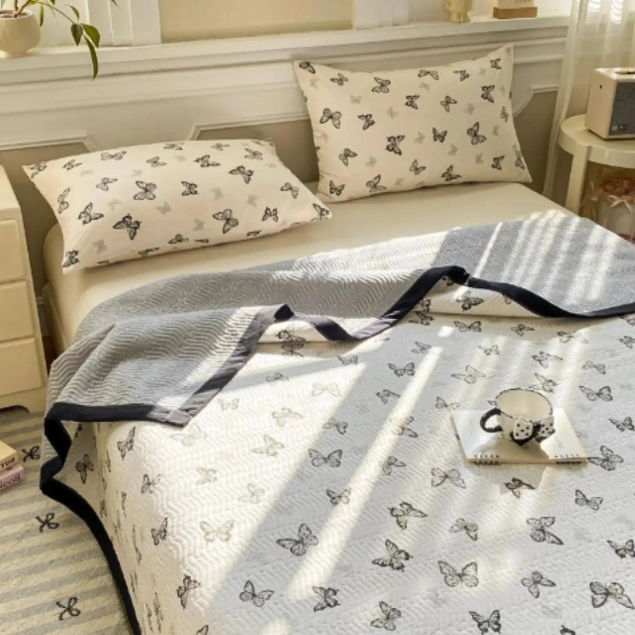 White microfiber quilt bedding set with black butterfly pattern and two matching pillowcases.