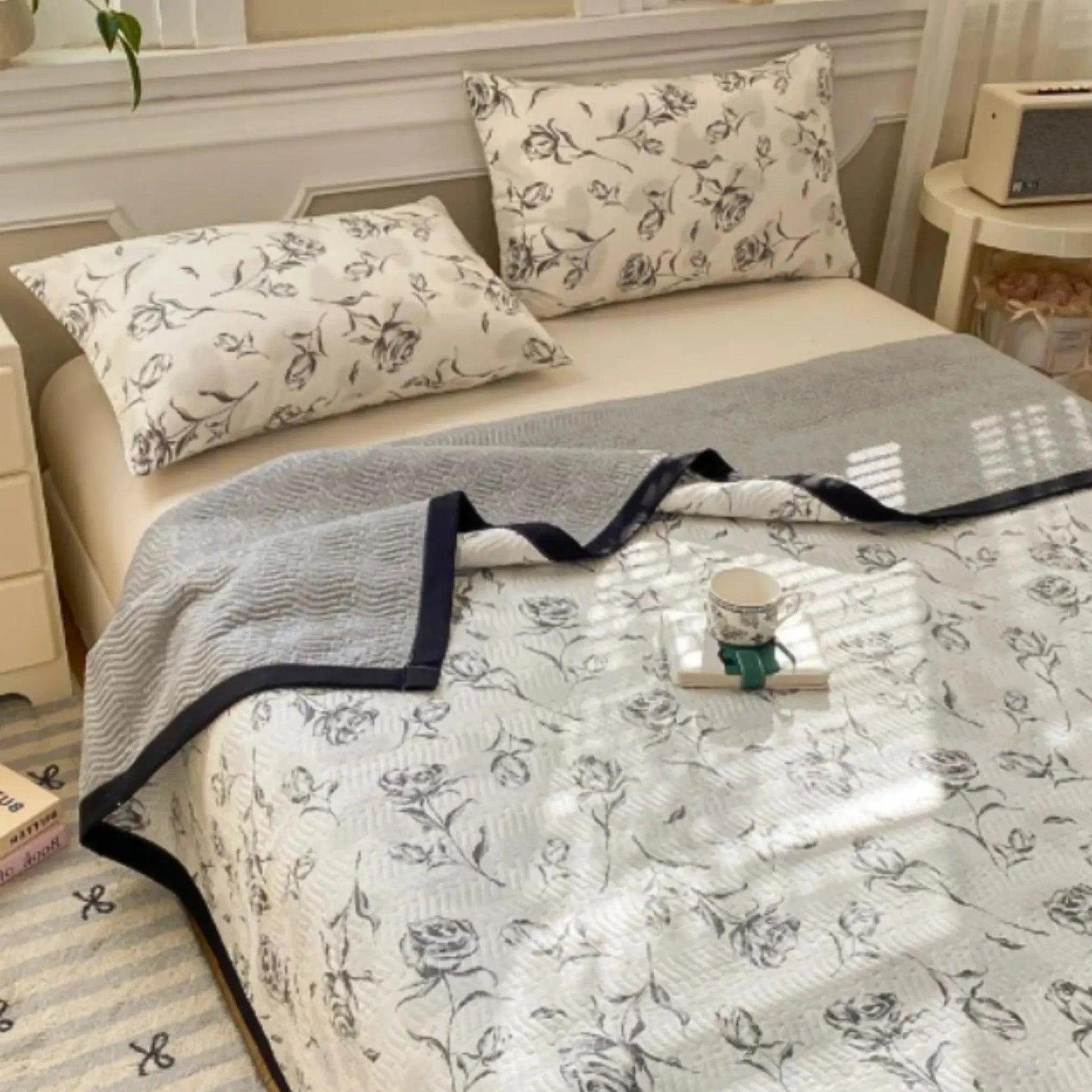 Floral microfiber quilt bedding set with grey and white rose pattern, two pillows, and a grey throw.