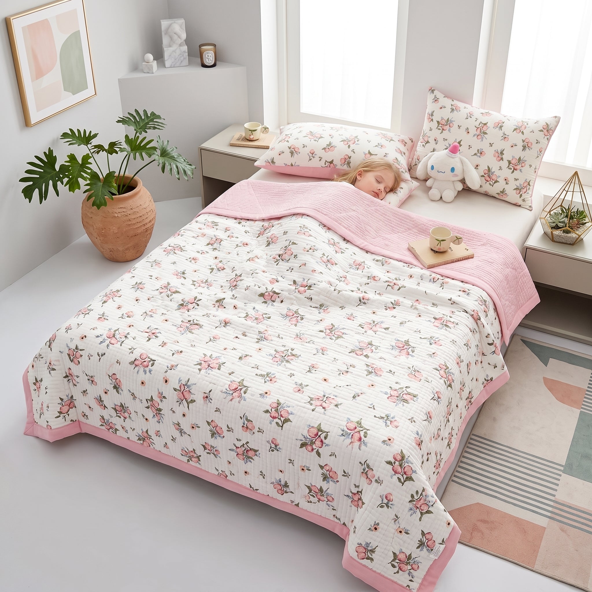 White microfiber quilt with pink floral pattern and solid pink reverse, on a bed with a sleeping child.