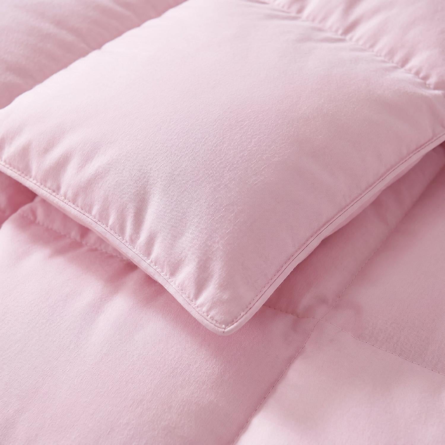 Close-up of a soft, fluffy pink cotton duvet insert comforter with quilted stitching.