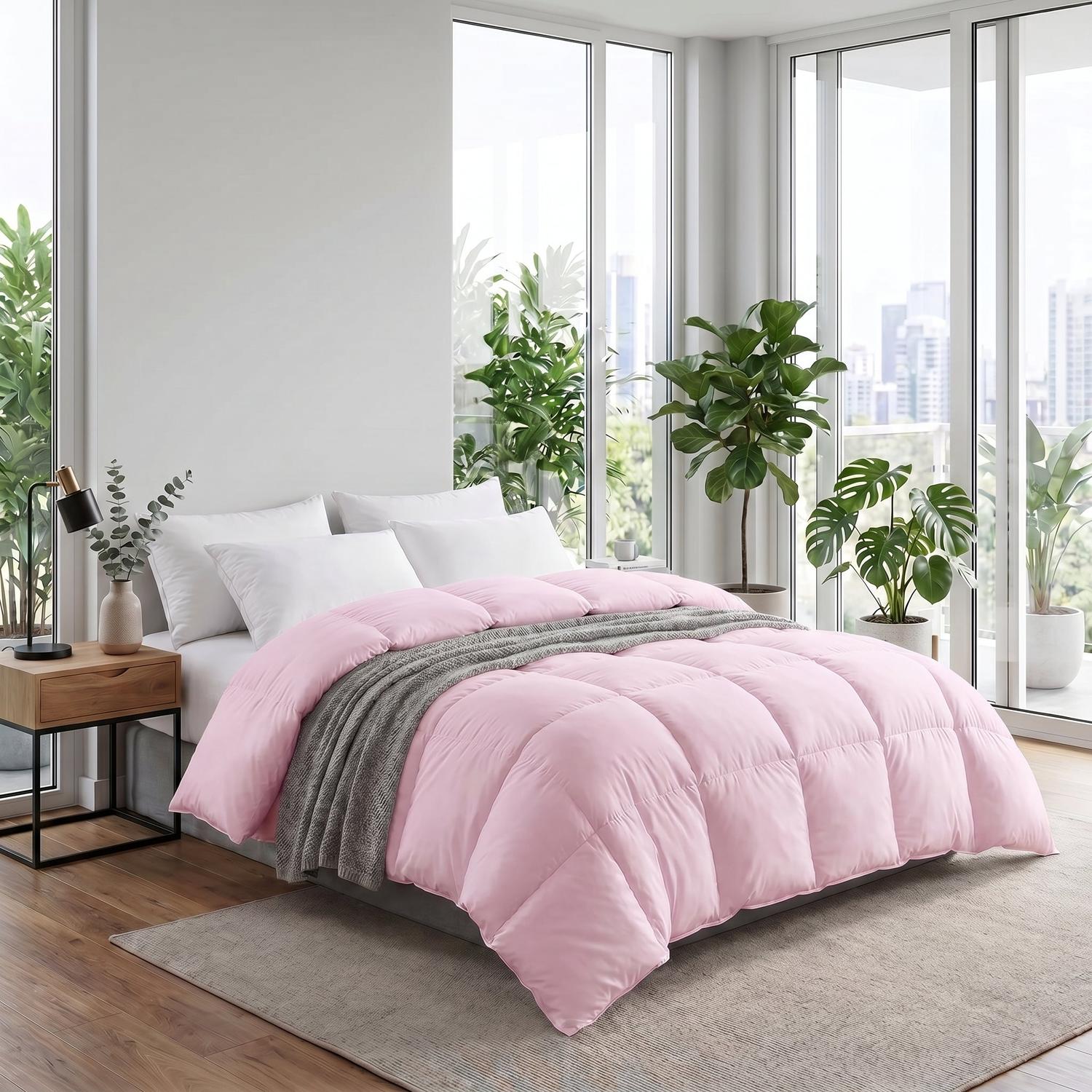 Pink fluffy cotton duvet insert comforter on a bed with white pillows and a grey throw blanket.