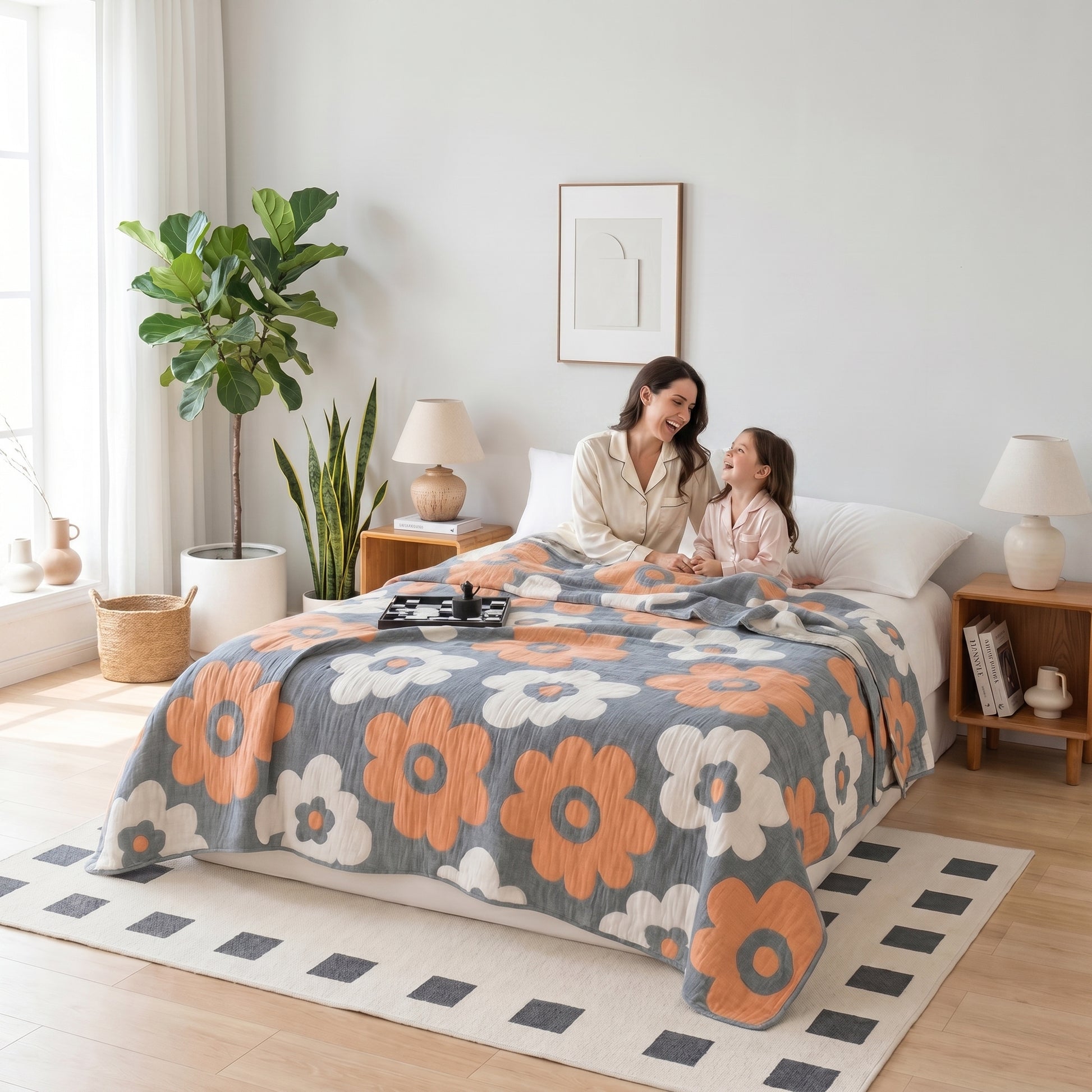 Mother and child on a bed with a gray and orange floral 6-layer cotton gauze blanket.